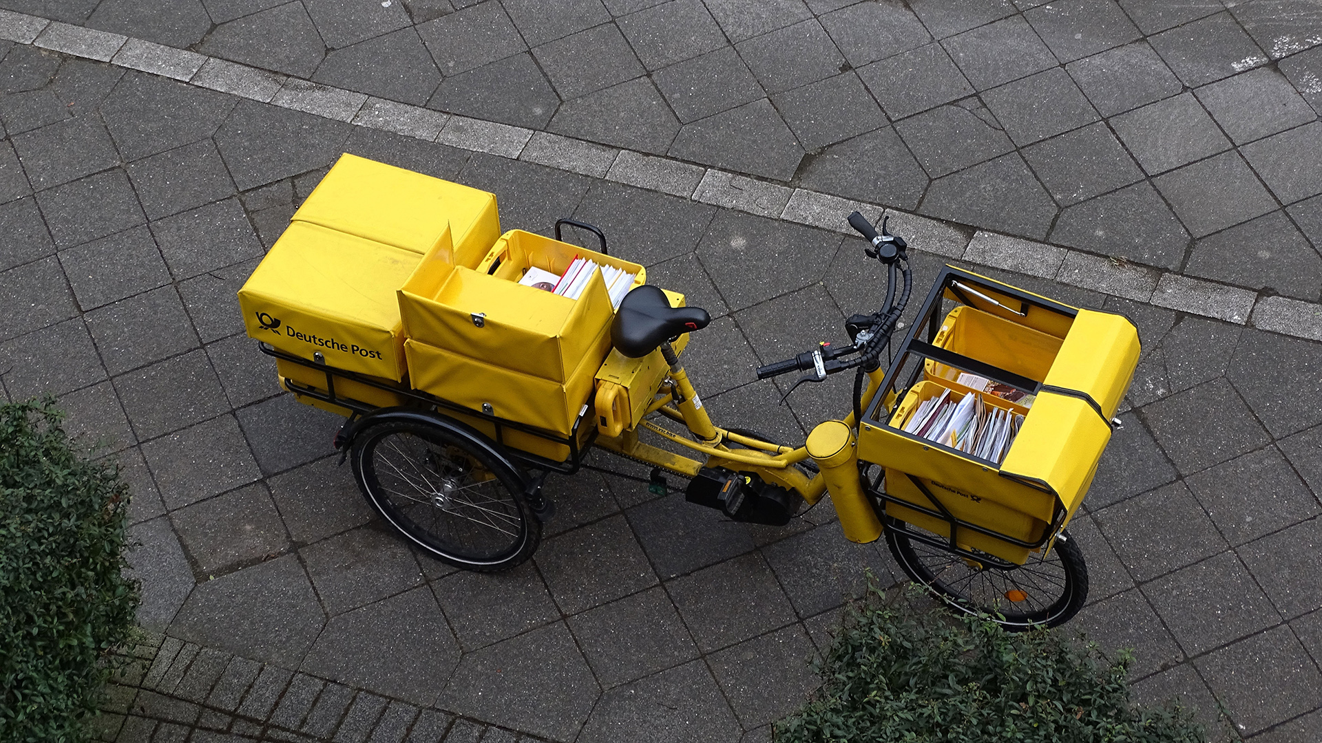 Ein Dienstfahrrad der Deutschen Post parkt während der Postzustellung. | picture alliance / Hans-Joachim