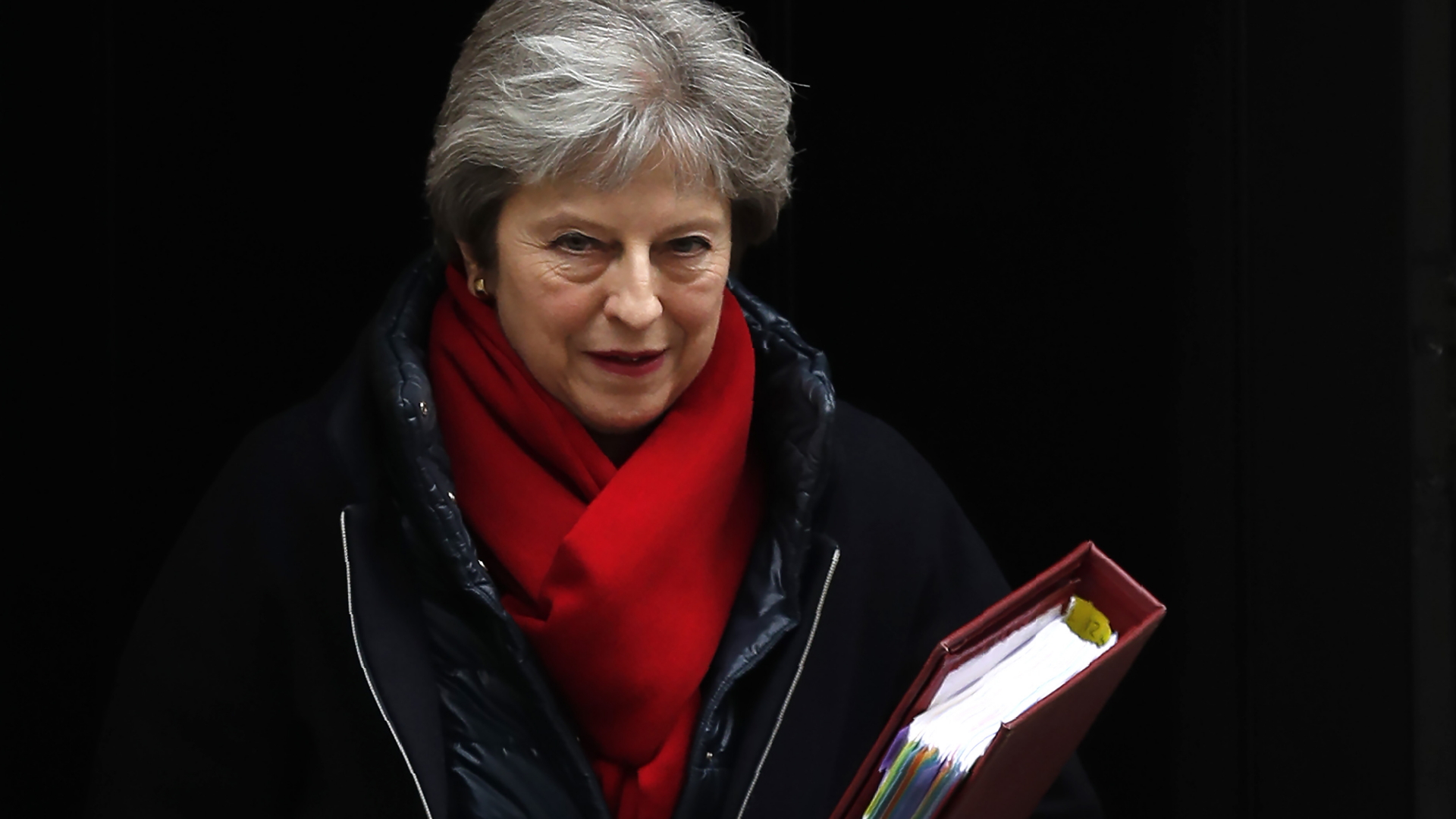 Die britische Premierministerin Theresa May verlässt in Mantel und mit rotem Schal Downing Street 10.