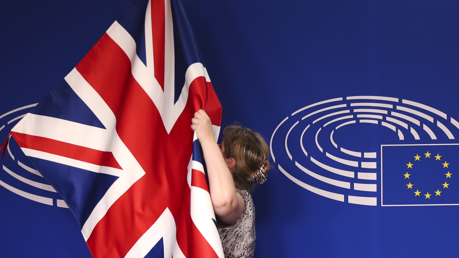 Ein Mitglied des EU-Protokolls justiert die britische Flagge. | AP