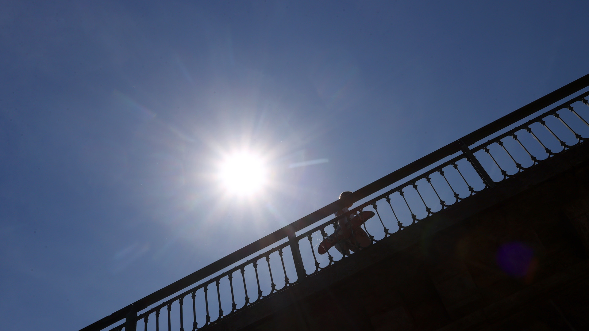 Ein Skater läuft im Sonnenschein über die Mainbrücke | picture alliance/dpa