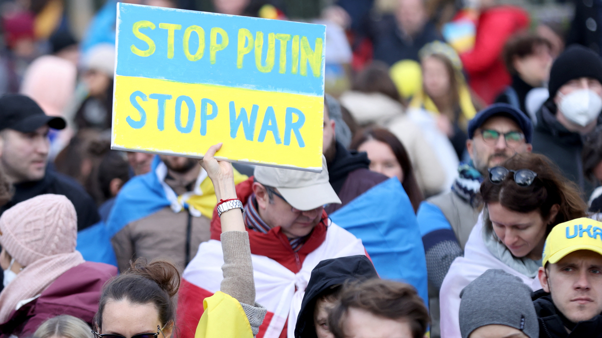 Eine Frau hält auf einer Anti-Kriegs-Demonstration in Brüssel ein Schild mit der Aufschrift "Stop Putin, stop war". | REUTERS