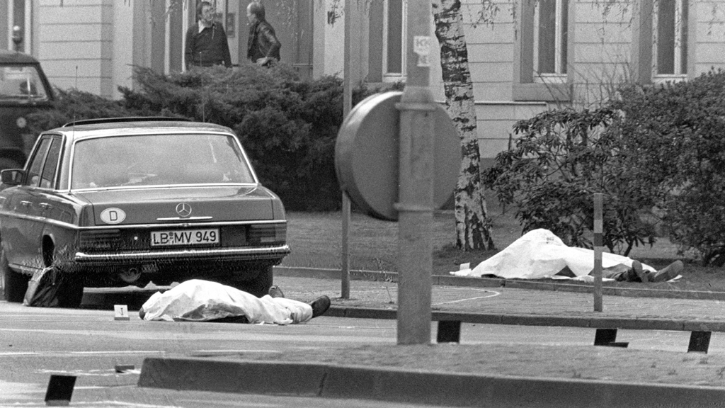 Der Tatort mit den zugedeckten Leichen von Siegfried Buback (rechts hinten) und seines Fahrers (links) sowie der Dienstwagen des Generalbundesanwaltes in Karlsruhe | picture-alliance/ dpa