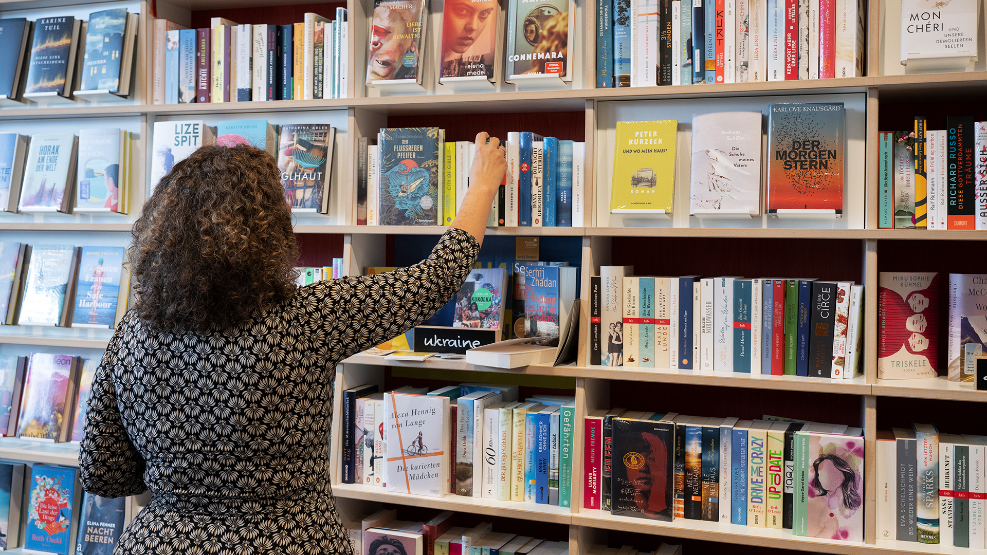 Ein Frau nimmt ein Buch aus dem Regal einer Buchhandlung | dpa