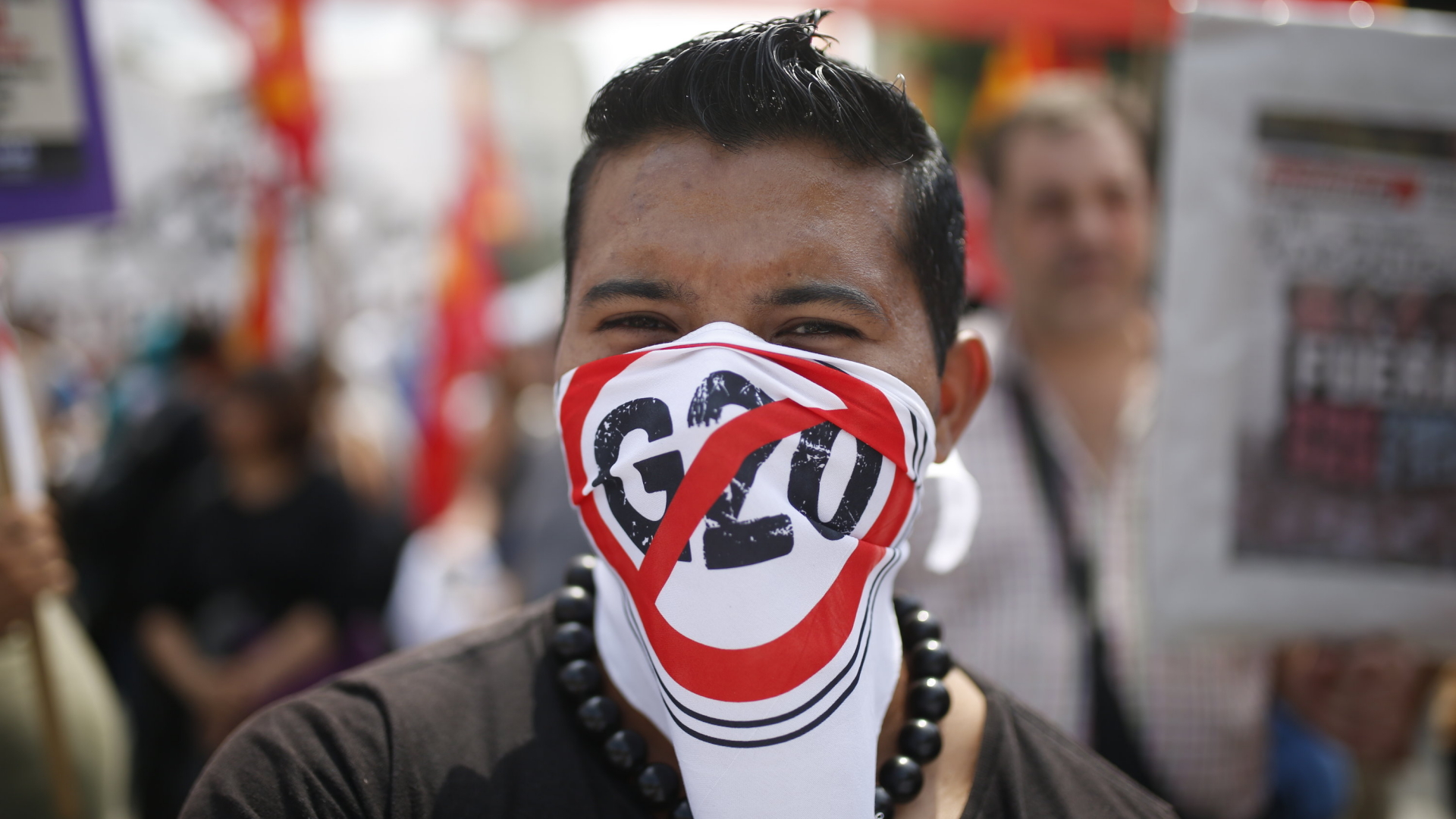 Ein vermummter Demonstrant nimmt an einem Protest gegen den G20-Gipfel teil.  | Bildquelle: dpa