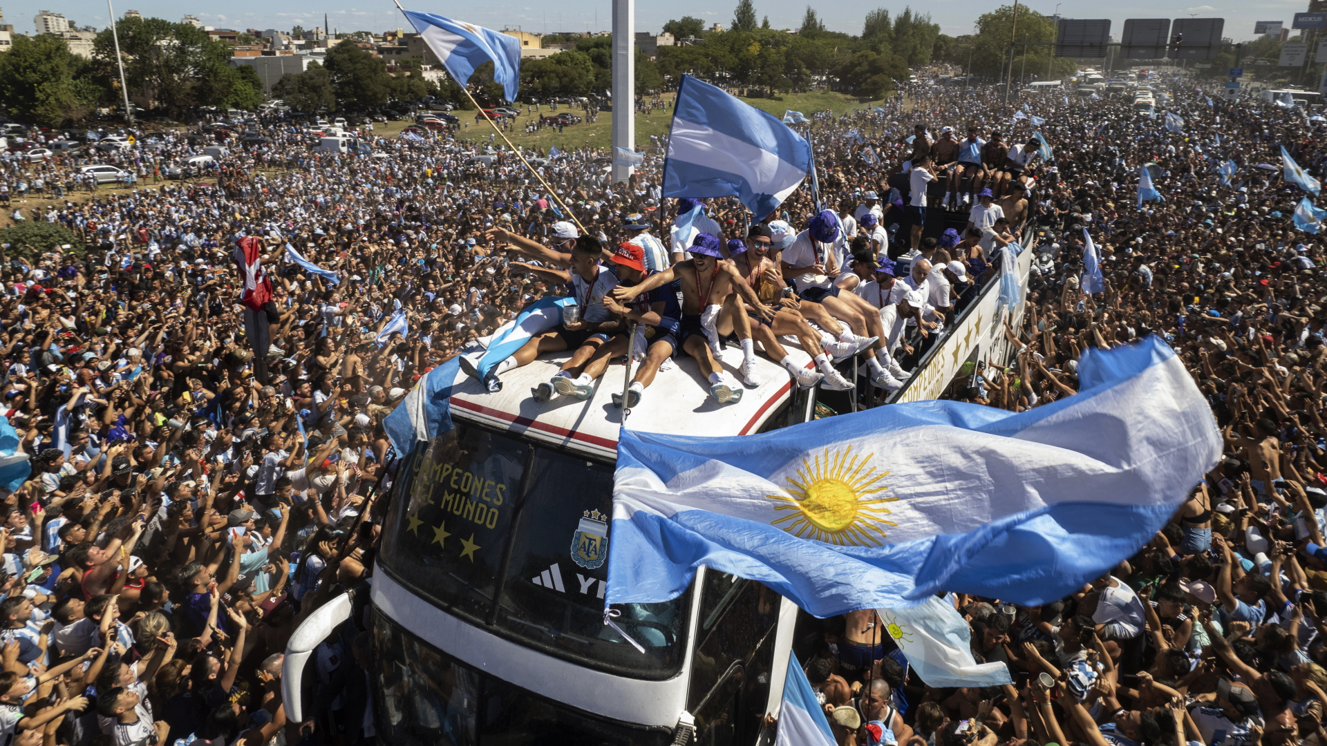 Ein offener Bus mit den argentinischen Fußball-Weltmeistern fährt in Buenos Aires durch Menschenmassen. | dpa