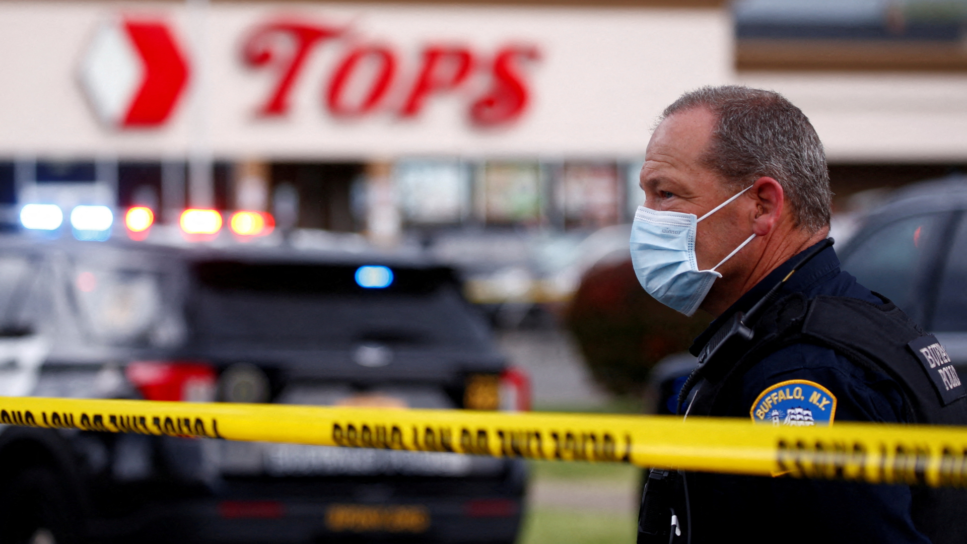Ein Polizist steht hinter einer Polizeiabsperrung vor einem Supermarkt in Buffalo. | REUTERS