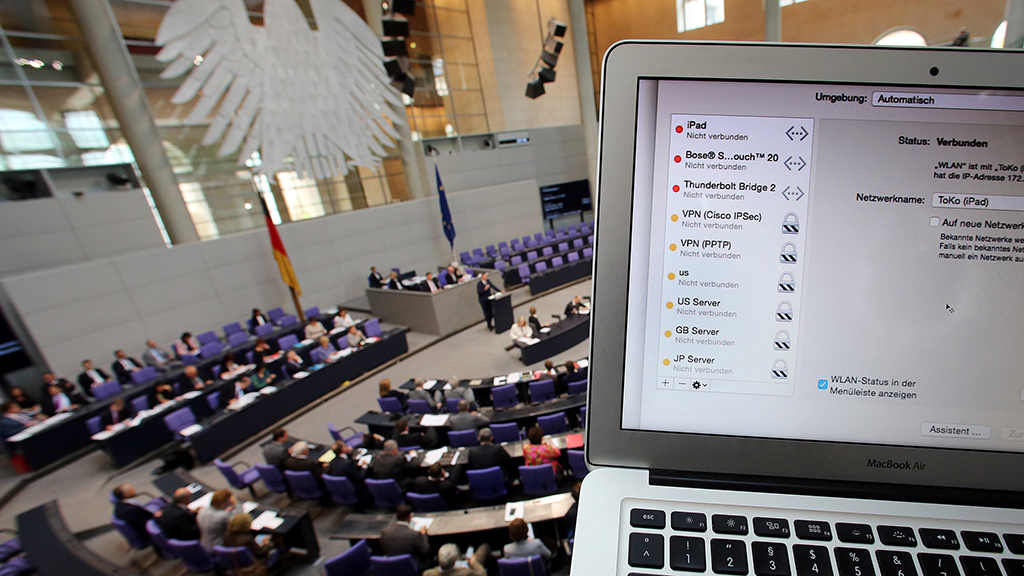 Ein Computer wird im Plenarsaal des Bundestags hochgehalten