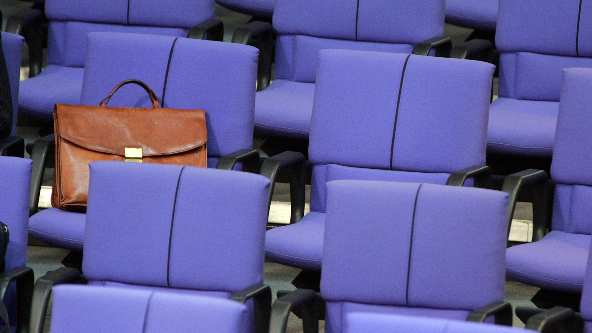 Eine Aktentasche liegt auf den leeren Sitzen im Bundestag. | picture alliance / photothek
