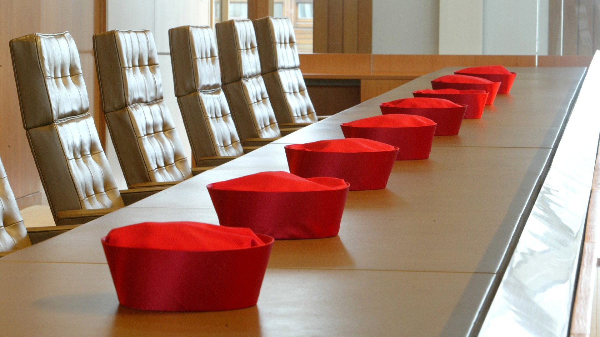 Barette von Richtern des Bundesverfassungsgerichts liegen auf dem Tisch eines Verhandlungssaals | picture-alliance/ dpa