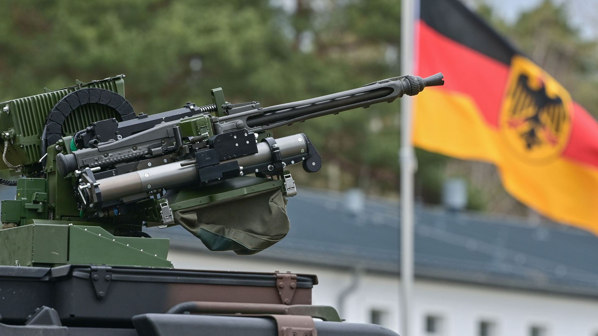 Ein Maschinengewehr vor der Nationalflagge Deutschlands. | picture alliance/dpa