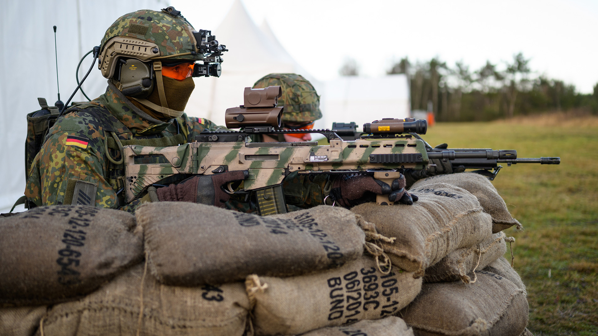 Soldaten der Bundeswehr haben mit dem Sturmgewehr vom Typ G36 A2 während einer Vorführung hinter Sandsäcken Stellung bezogen. | dpa