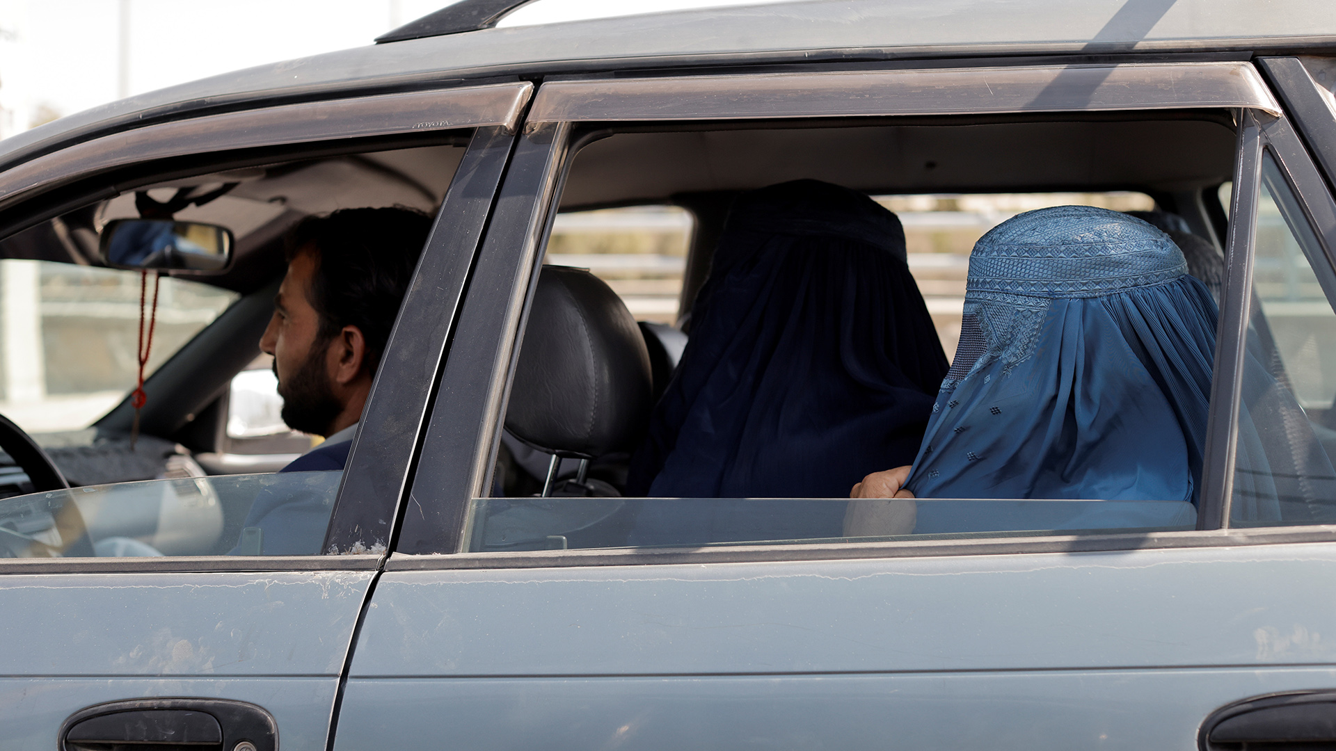 Zwei Frauen in Burkas auf der Rückbank eines Autos in Kabul, Afghanistan. | REUTERS