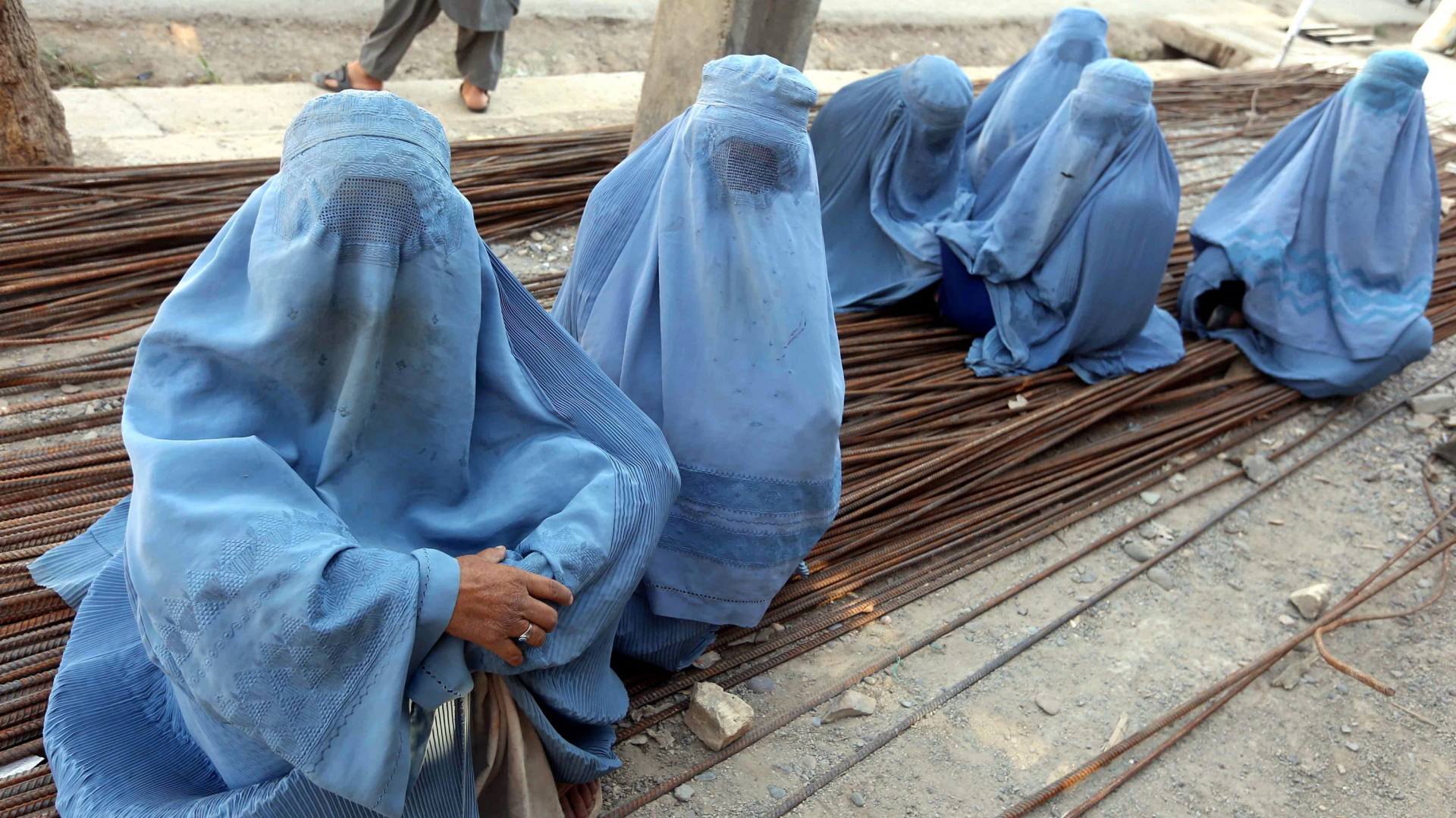 Afghanische Frauen tragen eine Burka und warten auf eine Essensration während des muslimischen Fastenmonats Ramadan in Herat, Afghanistan. | dpa