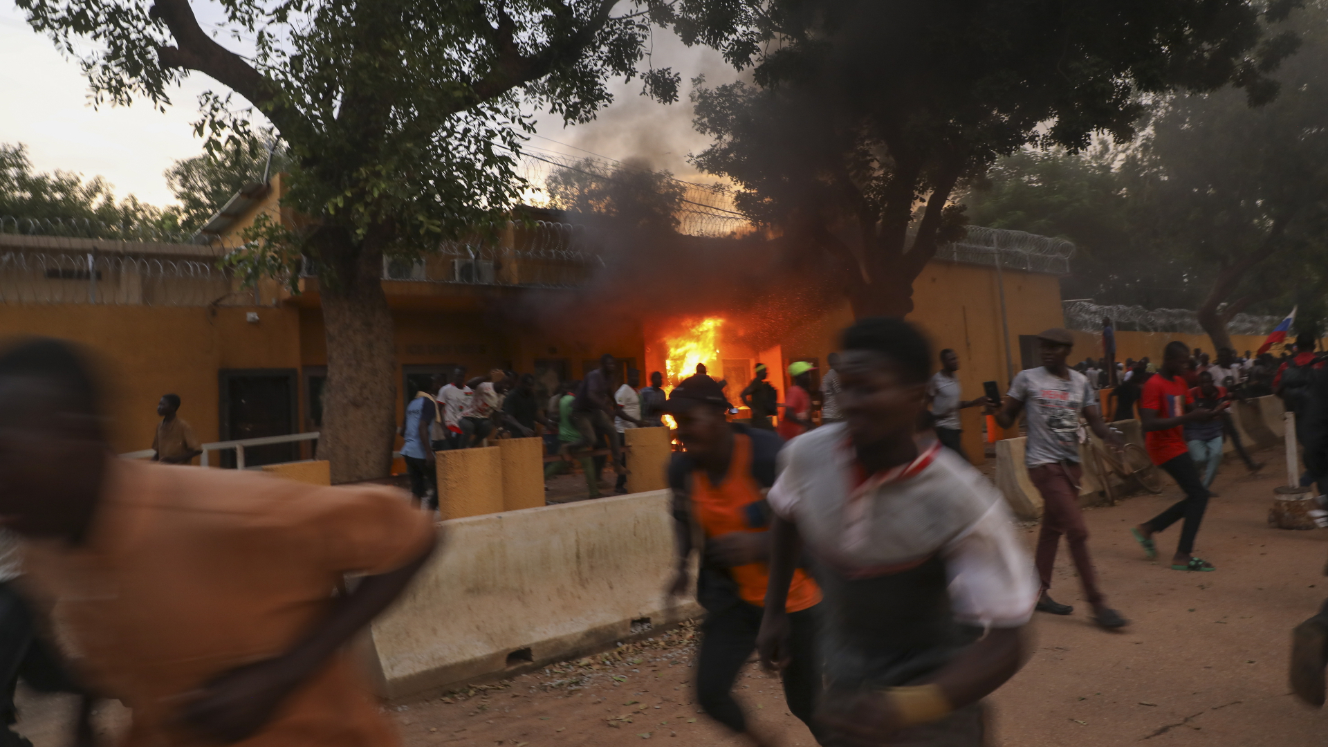 Einwohner von Ouagadougou laufen vor der französischen Botschaft, die in Ouagadougou, Burkina Faso, in Brand gesteckt wurde. | EPA