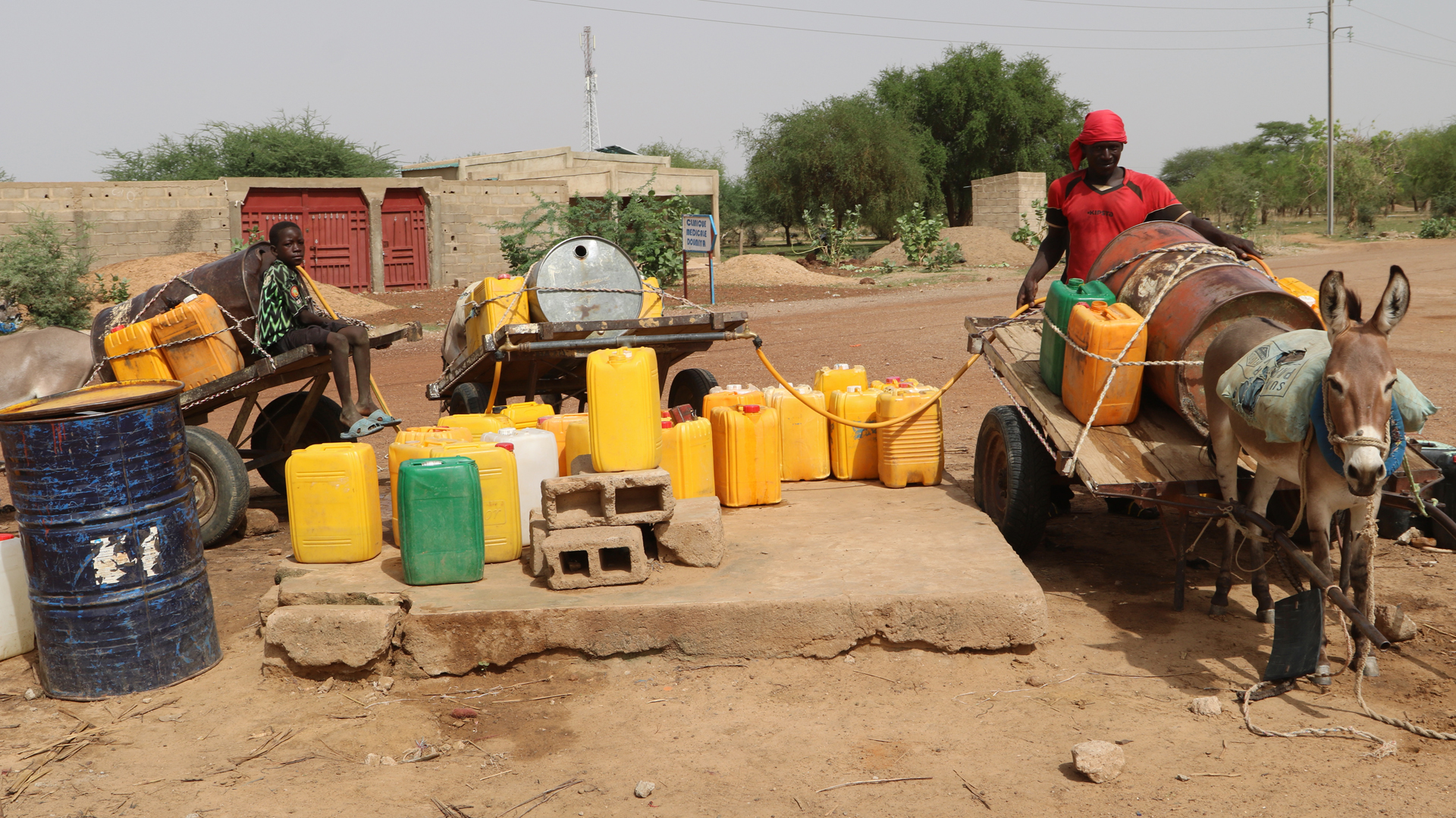 Bewohner der Stadt Dori im Norden Burkina Fasos (Archivbild von 2021) füllen Behälter mit Wasser. | picture alliance / ASSOCIATED PR