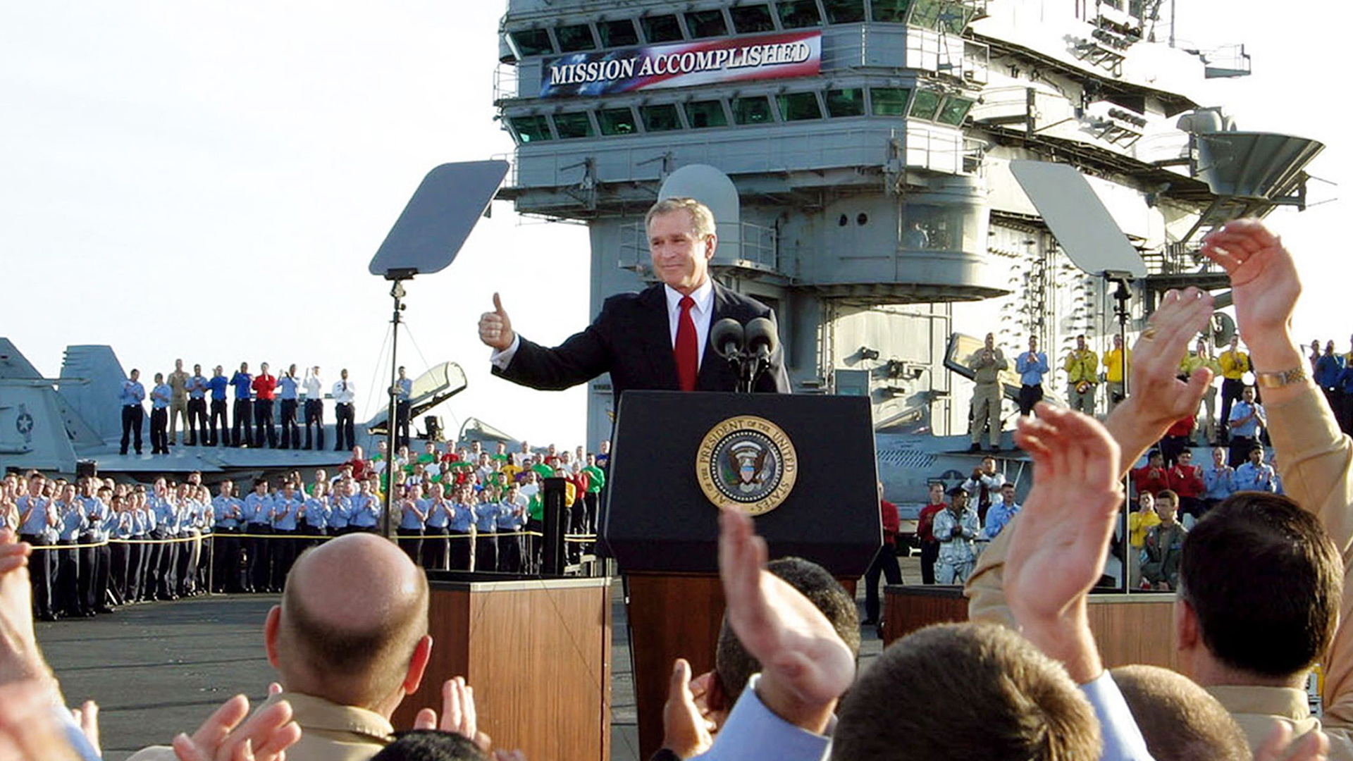 George W. Bush spricht am 1. Mai 2003 auf dem Flugzeugträger "USS Abraham Lincoln" zu US-Soldaten. | picture alliance / ASSOCIATED PR
