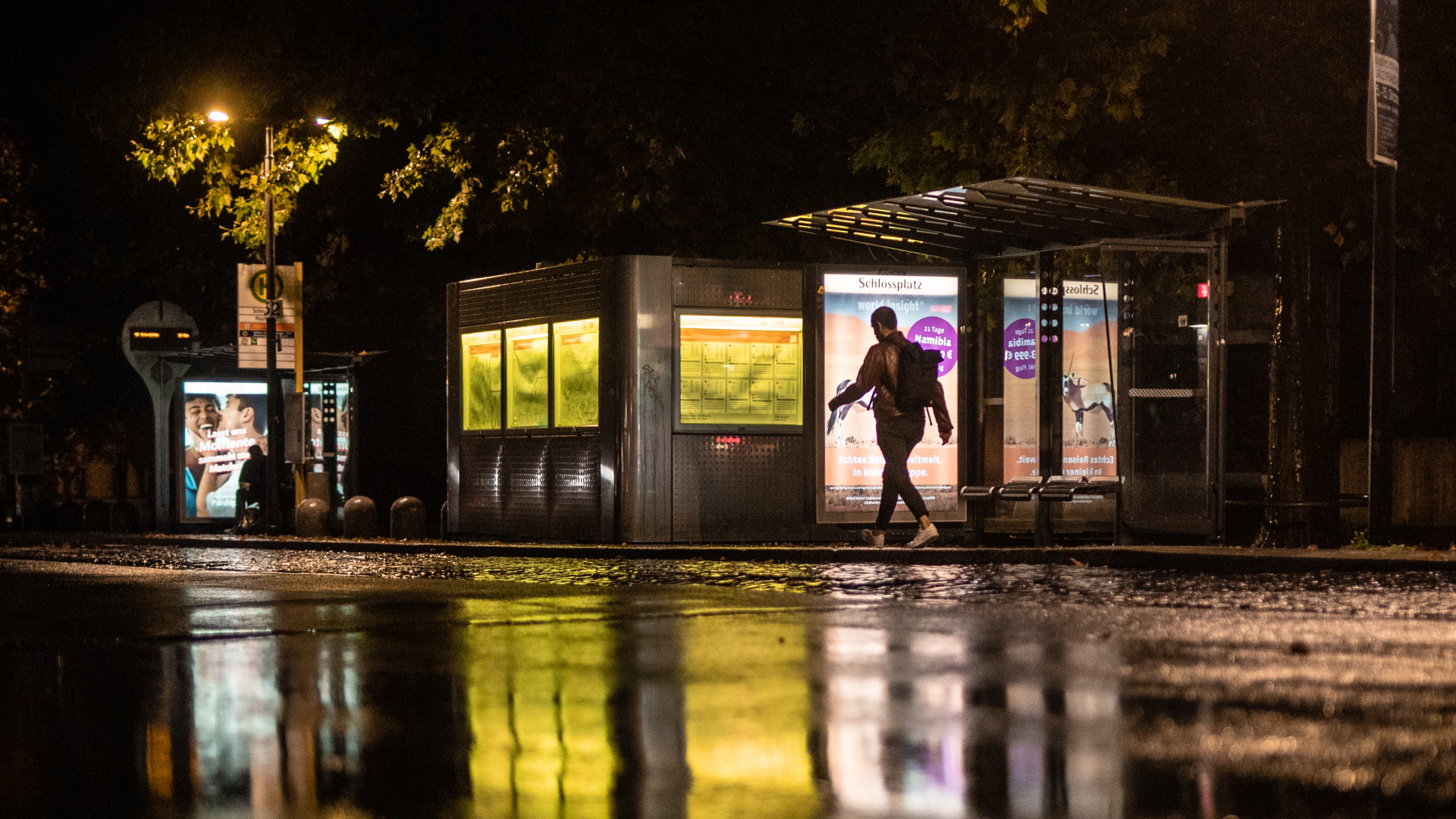 Werbeanzeigen leuchtet an einer Bushaltestelle im Dunkeln. | dpa