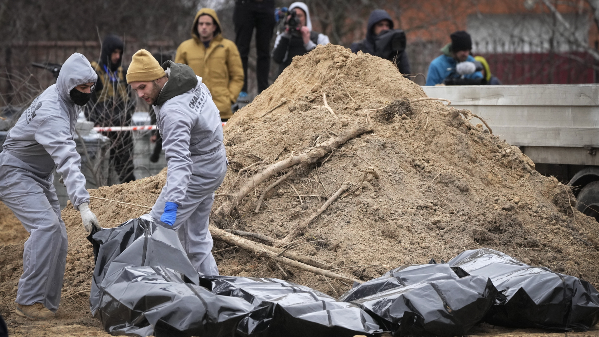 Männer in Schutzkleidung exhumieren Leichen getöteter Zivilisten | dpa