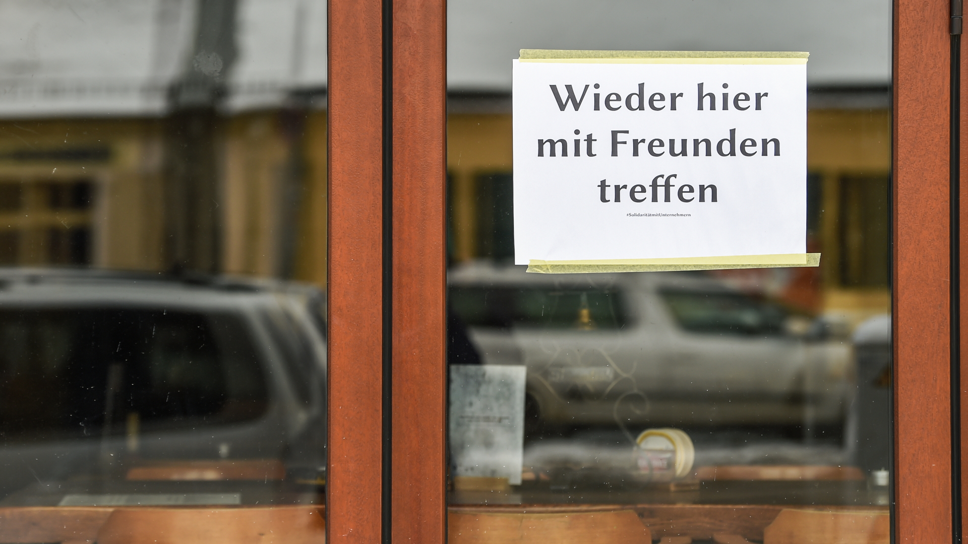 Am Fenster einer Bar in Friedrichshagen hängt ein Schild mit der Aufschrift "Wieder hier mit Freunden treffen"