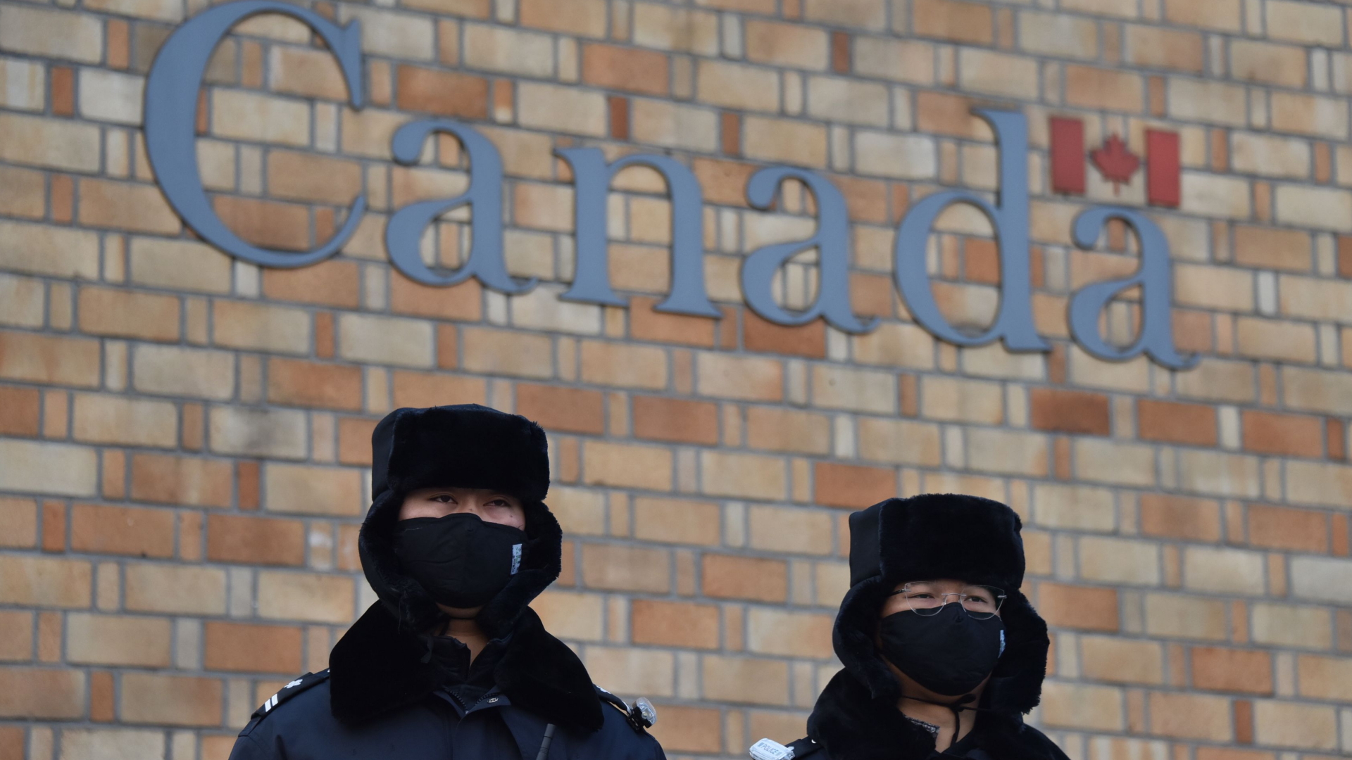 Chinesische Polizisten patrouillieren vor der kanadischen Botschaft in Peking | Bildquelle: AFP