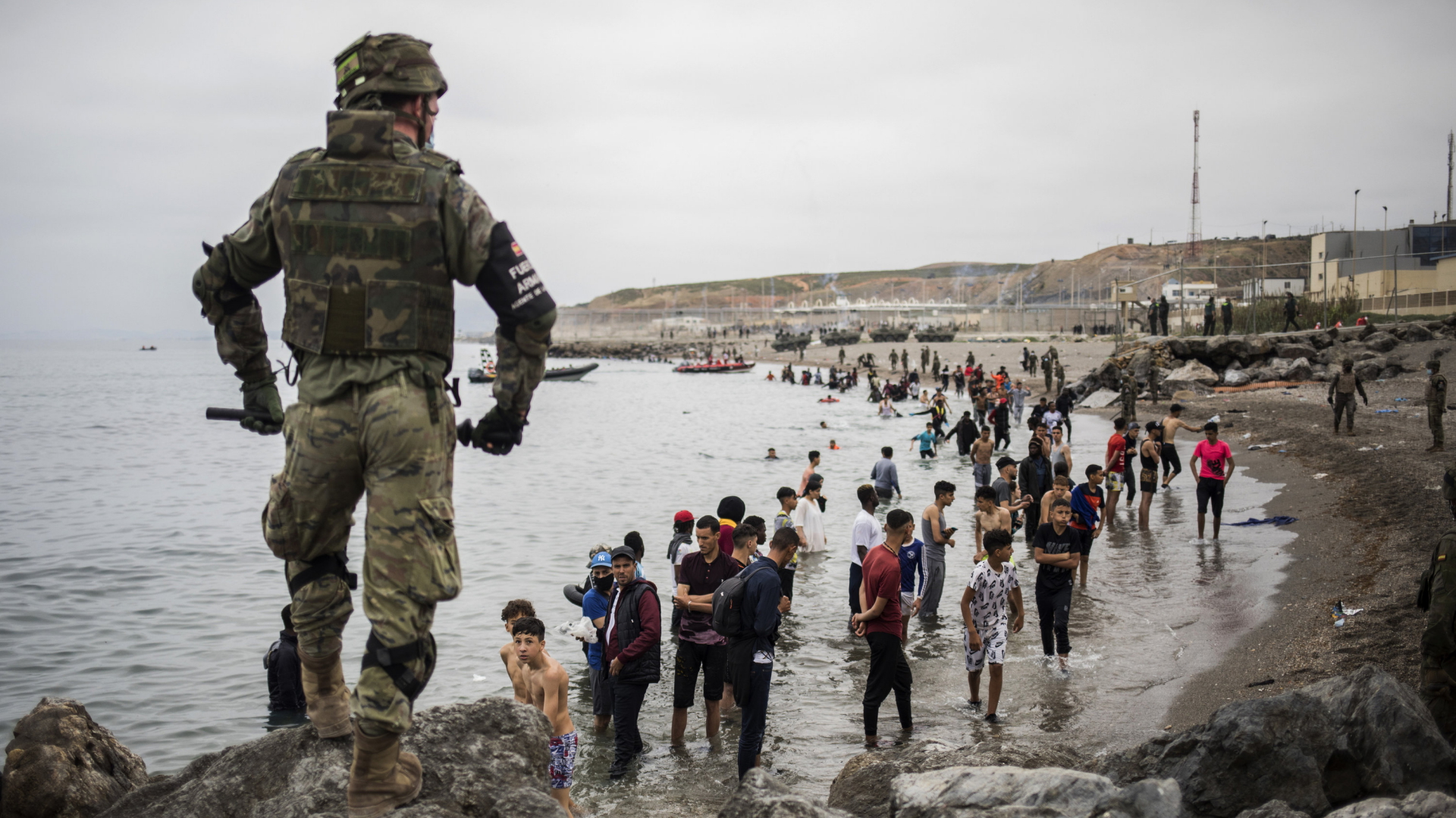 Migranten aus Marokko werden vom spanischen Militär bewacht | AP