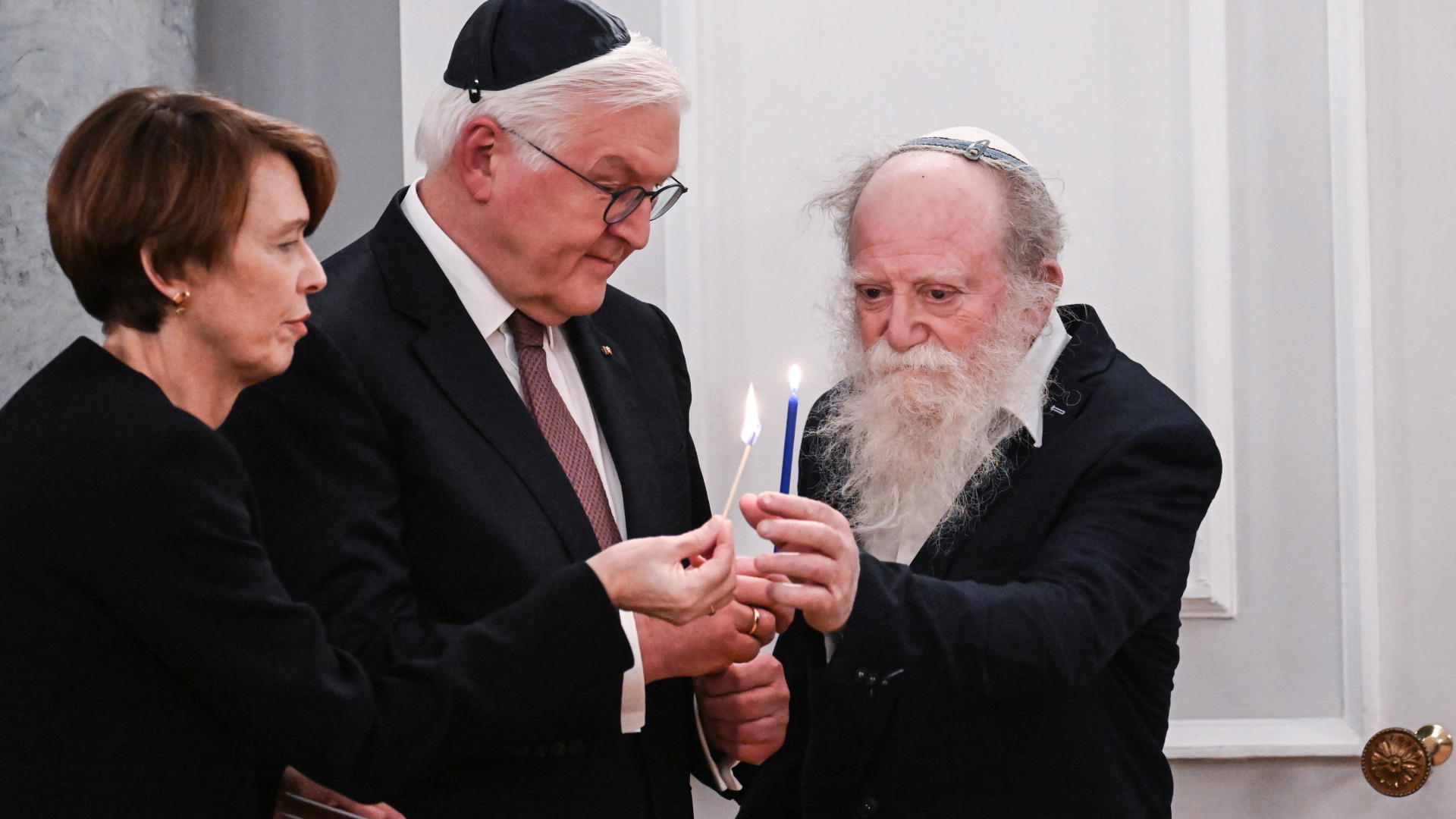 Elke Büdenbender, Frank-Walter Steinmeier und Yehuda Mansbach zünden Kerzen für das Chanukka-Fest an.  | EPA