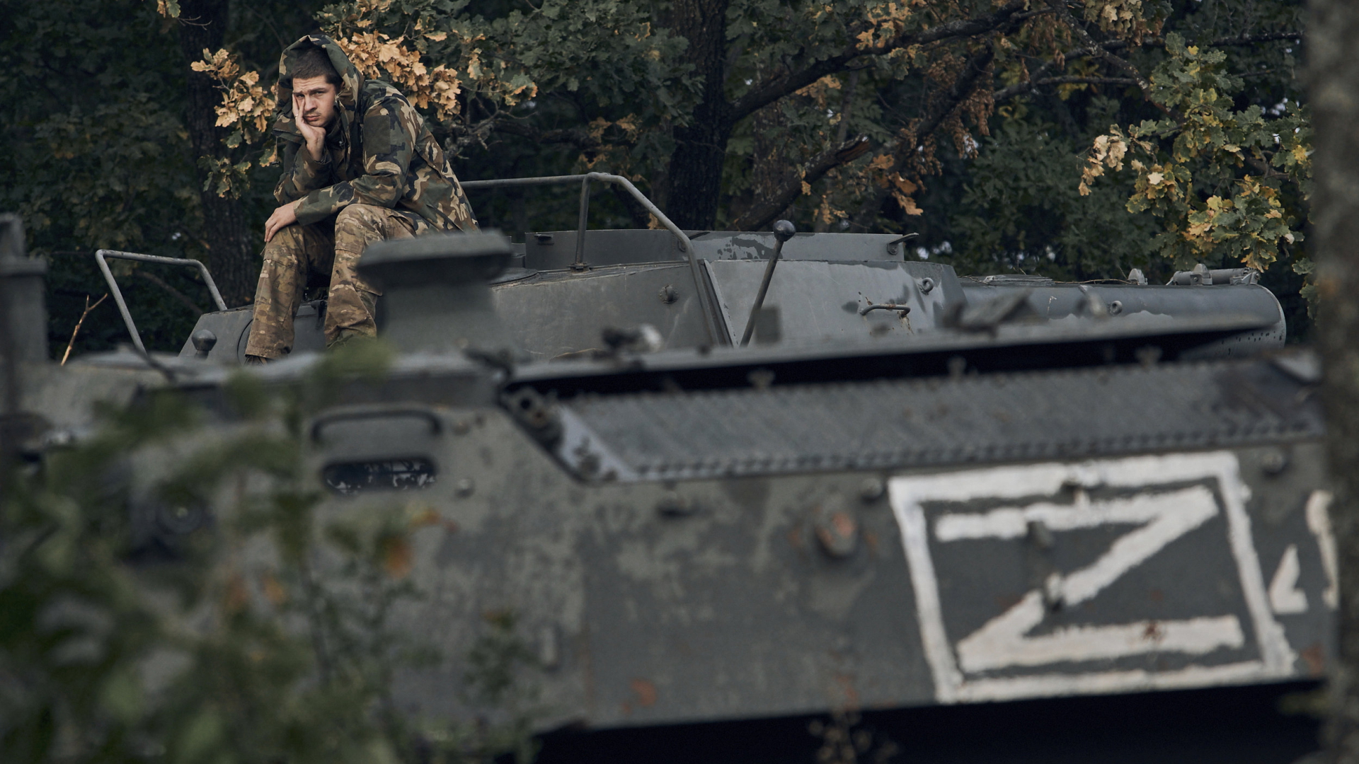 Ein ukrainischer Kämpfer sitzt auf einem in der Region Charkiw zurückgelassenen russischen Panzer. | AP