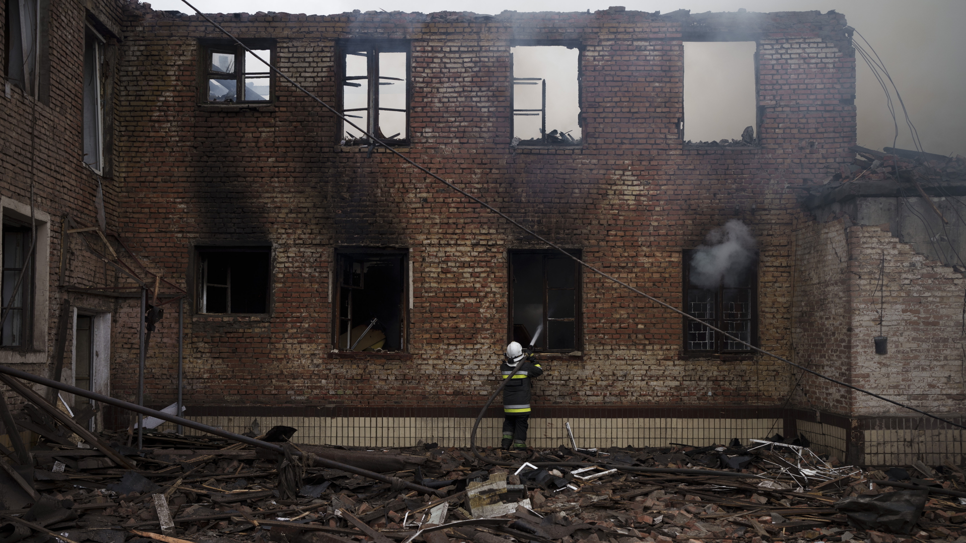 Ein Feuerwehrmann arbeitete daran, ein Feuer bei einem Haus nach einem russischen Angriff in Charkiw zu löschen.  | dpa