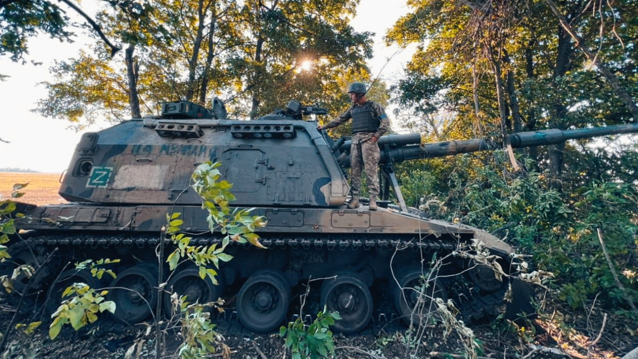 Ein junger ukrainischer Soldat steht auf einer erbeutete russischen Panzerhaubitze in der Region Charkiw (Ukraine) | via REUTERS