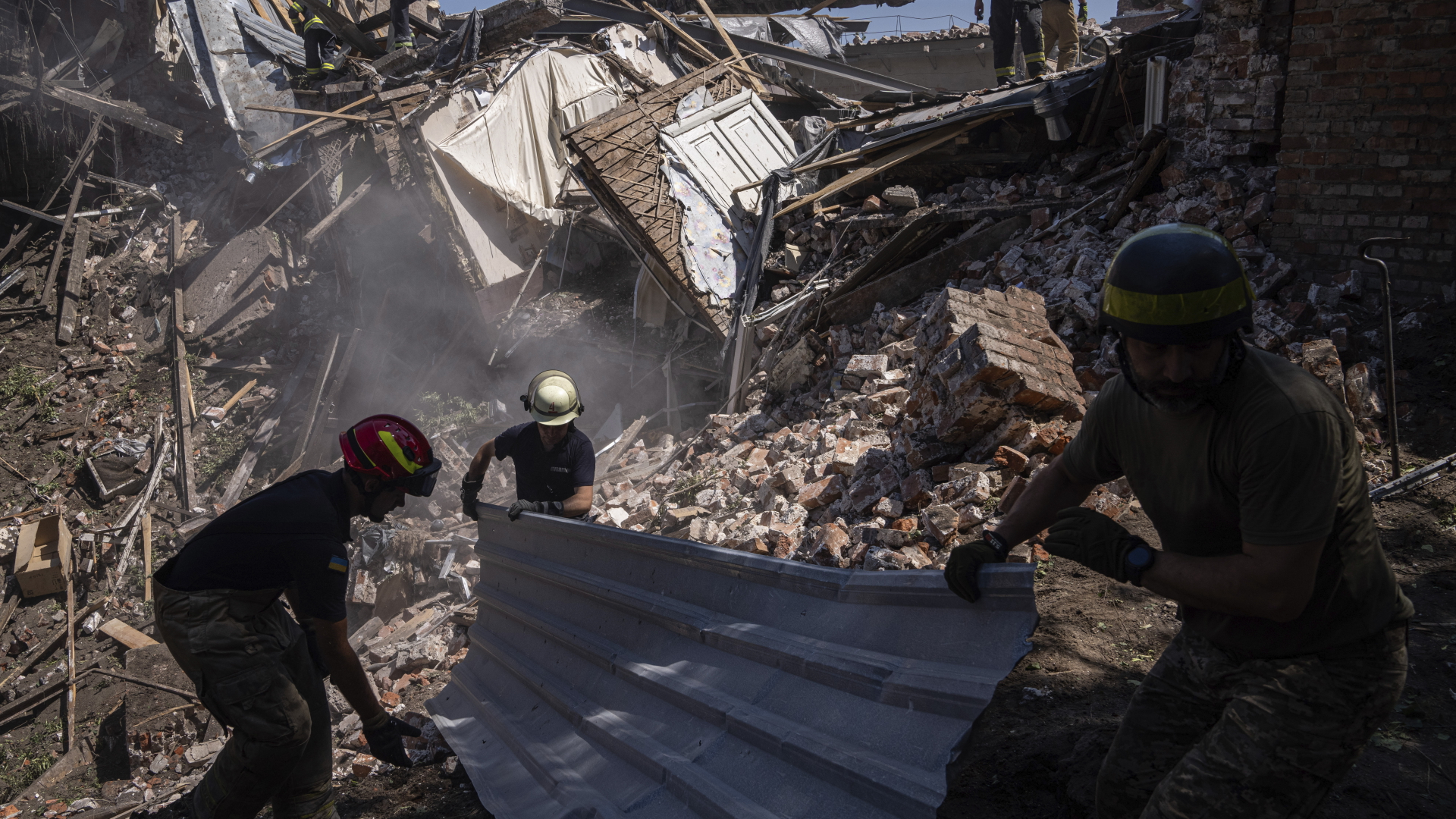 Rettungskräfte räumen in Charkiw Trümmer eines zerstörten Hauses nach einem russischen Angriff weg. | dpa