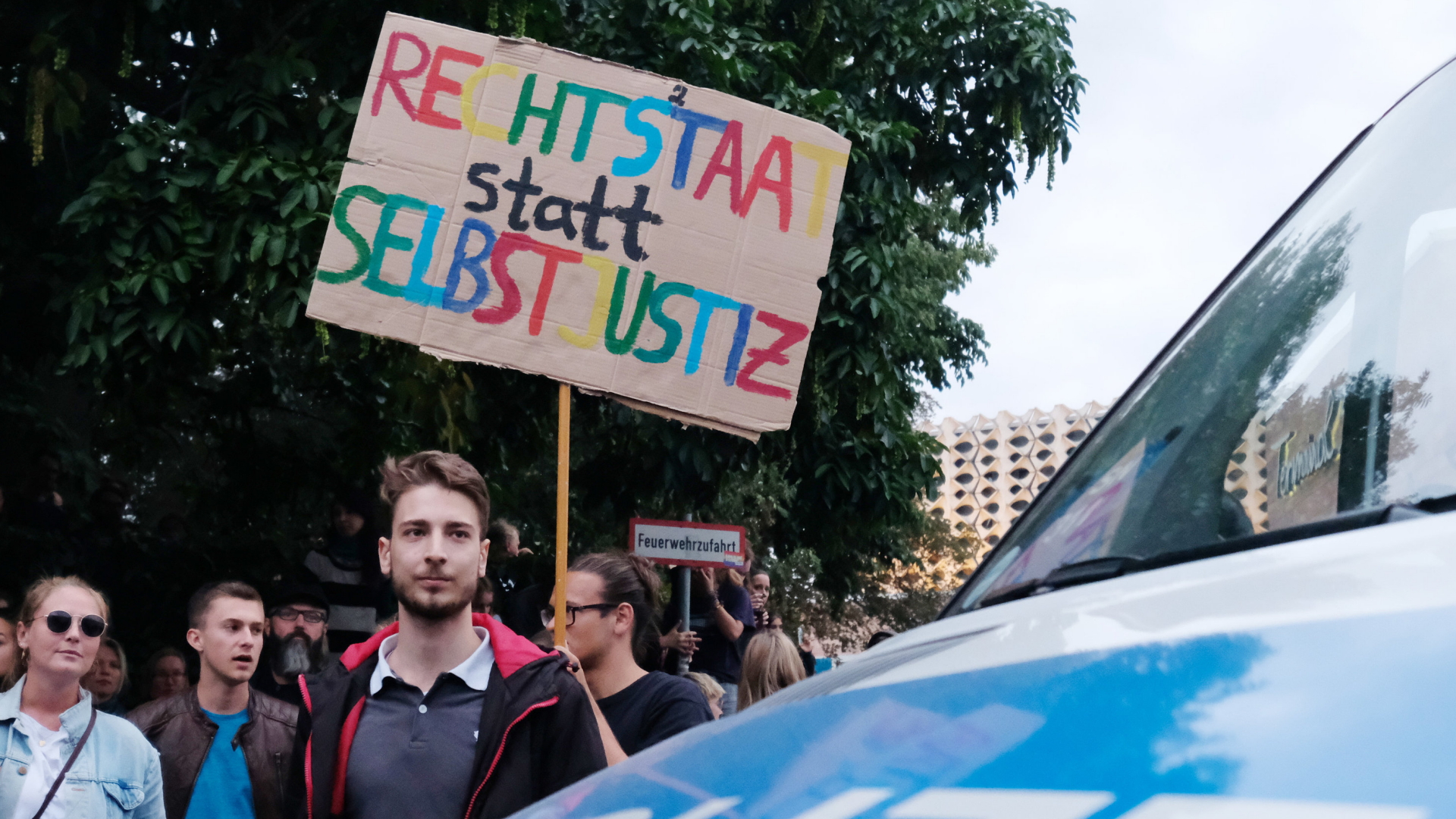Demonstrant in Chemnitz tritt mit einem Plakat für den Rechtsstaat und gegen Selbstjustiz ein
