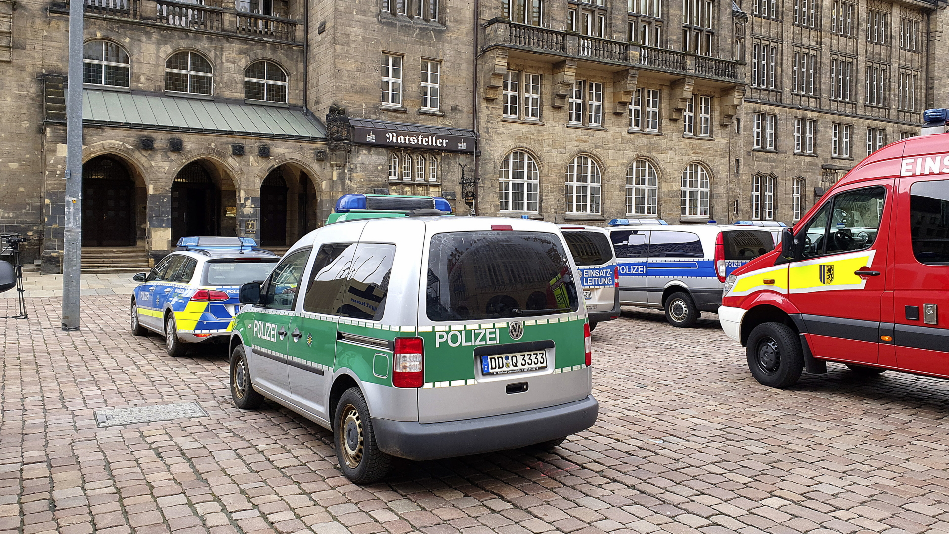 Einsatzkräfte der Polizei und Feuerwehr stehen vor dem Chemnitzer Rathaus nach einer Bombendrohung.