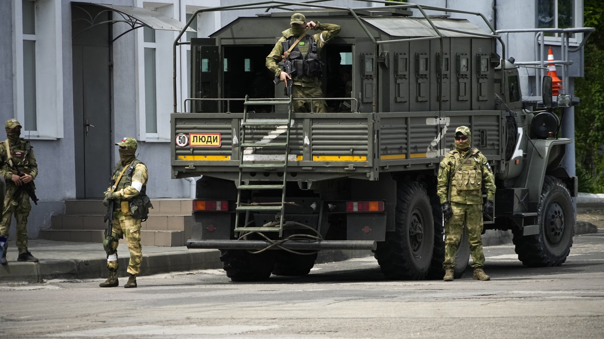 Russische Soldaten bewachen einen Journalistenbesuch in Cherson (Mai 2022) | AP