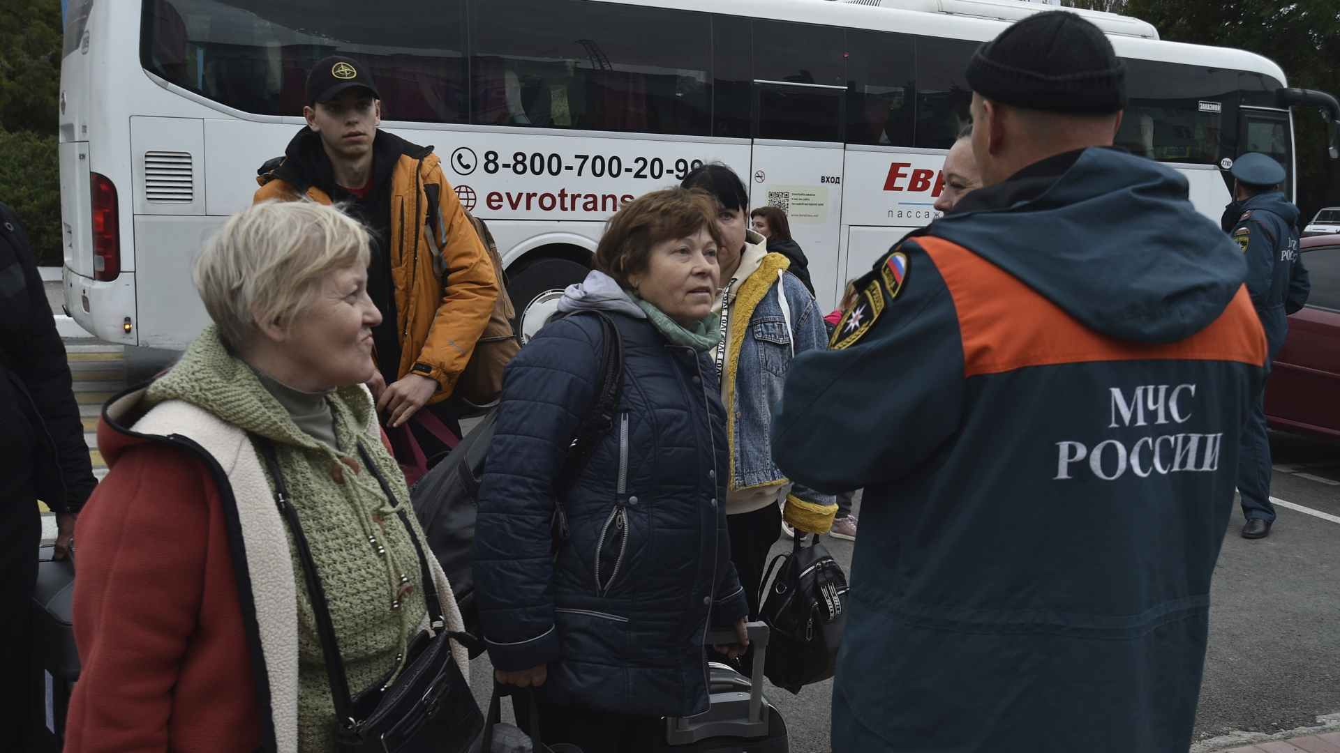 Ein russischer Mitarbeiter des Katastrophenschutzes spricht mit evakuierten Personen aus Cherson, während ihrer Ankunft am Bahnhof in Dschankoj | dpa