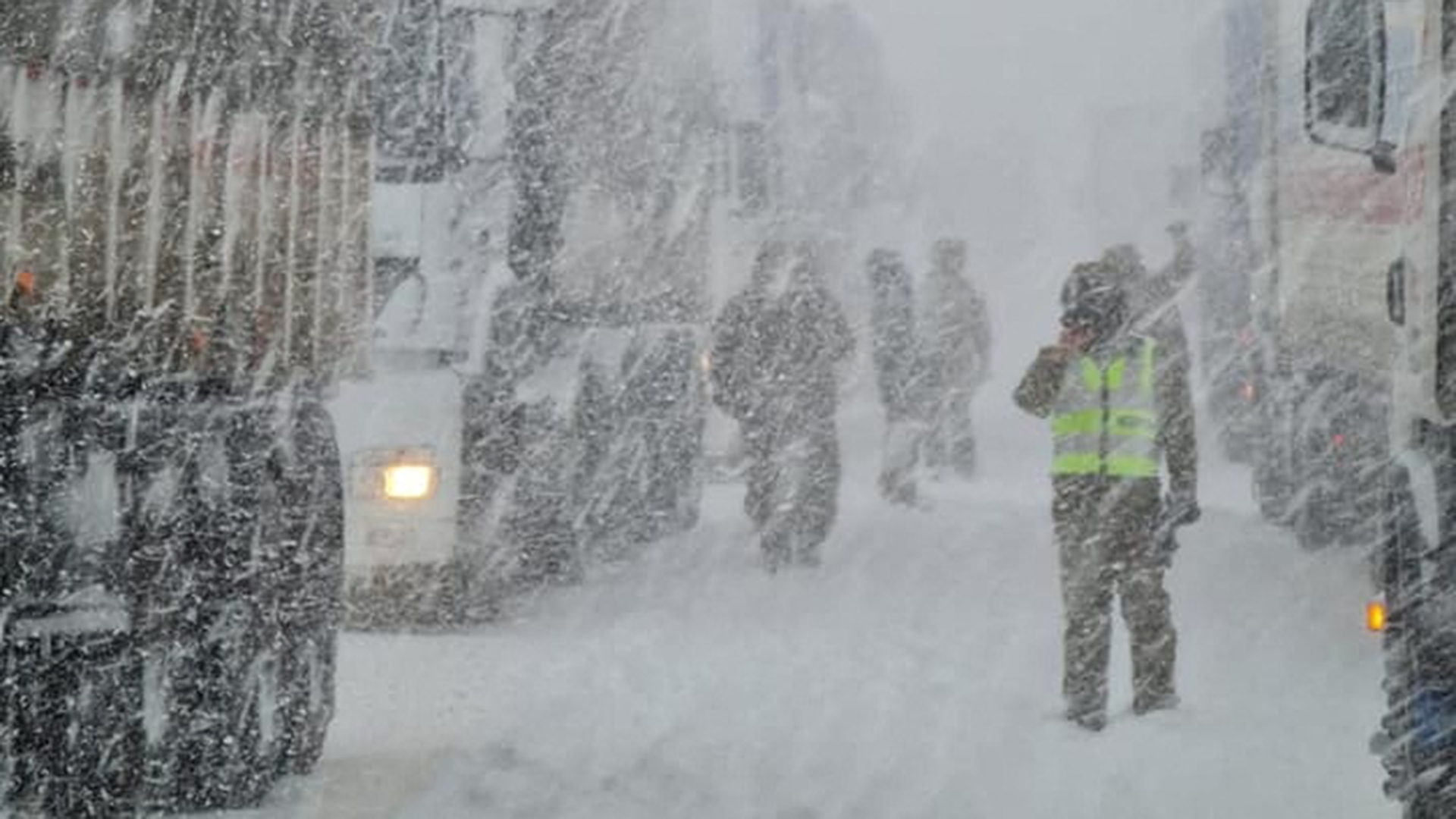 Ein Polizist arbeitet während eines Schneesturms in den Anden in der Nähe von Fahrzeugen auf einer Straße. | via REUTERS