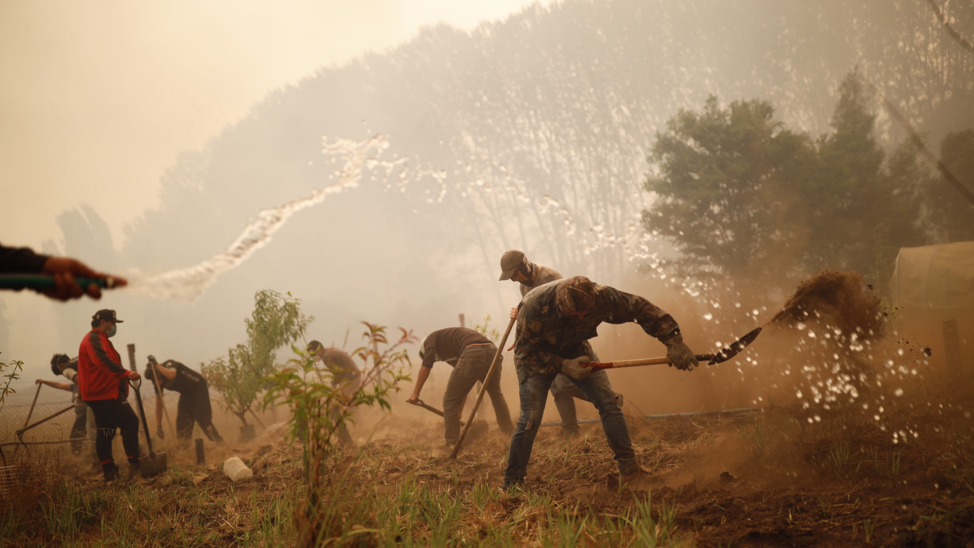 Feuerwehrleute und Anwohner bekämpfen bei Santa Juana (Chile) einen Waldbrand. | EPA