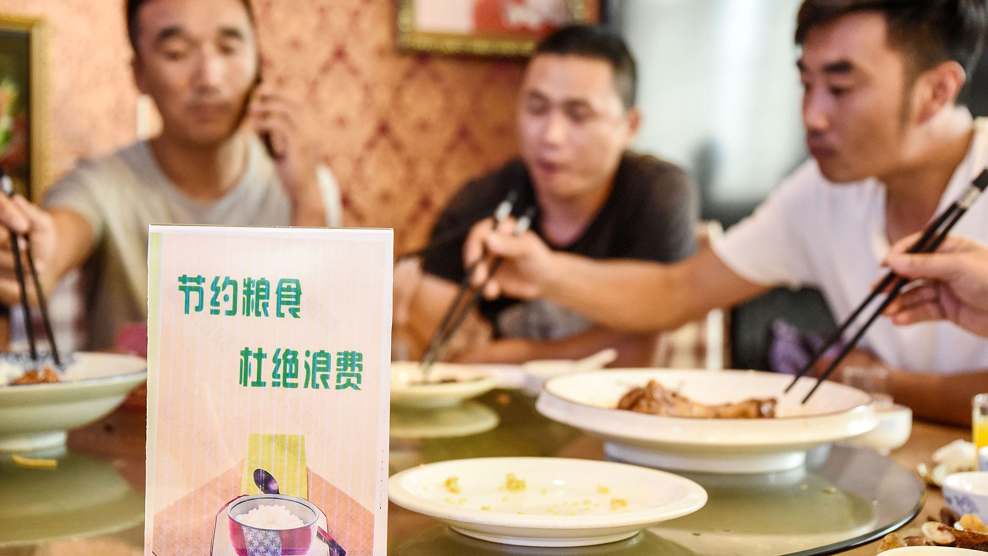 Ein Schild auf einem Tisch in einem Restaurant in China fordert die Gäste auf, Lebensmittel nicht zu verschwenden | AFP