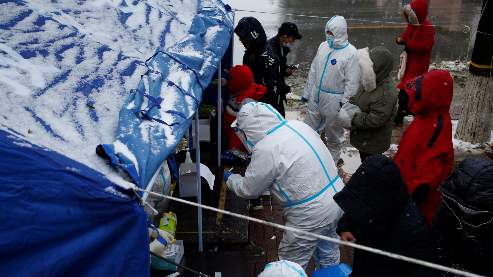 Menschen stehen in dicken Winterjacken an einem Corona-Test-Pavillon in Dalian. | VIA REUTERS
