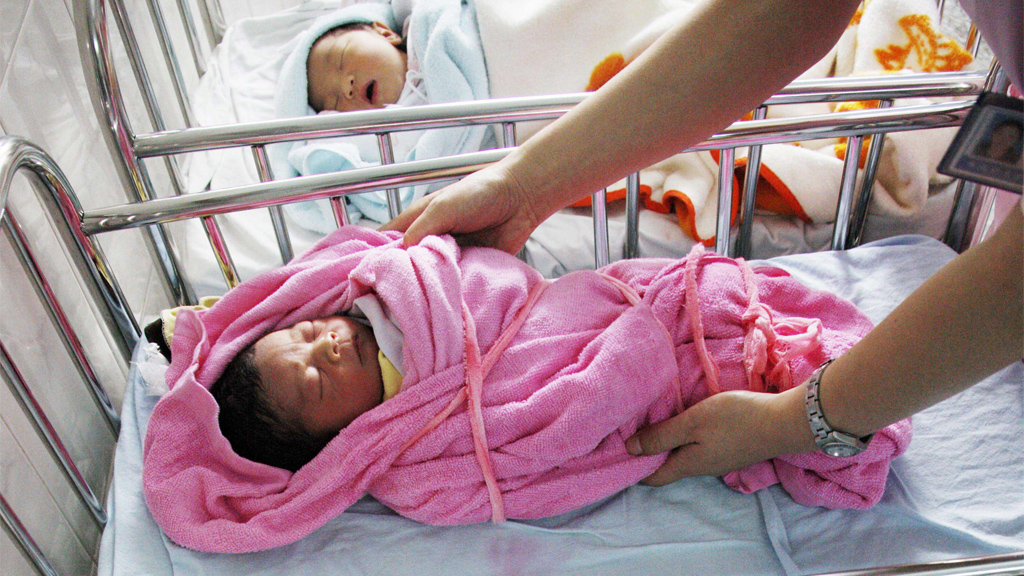 Eine Krankenschwester hält ein chinesisches Neugeborenes. | AFP