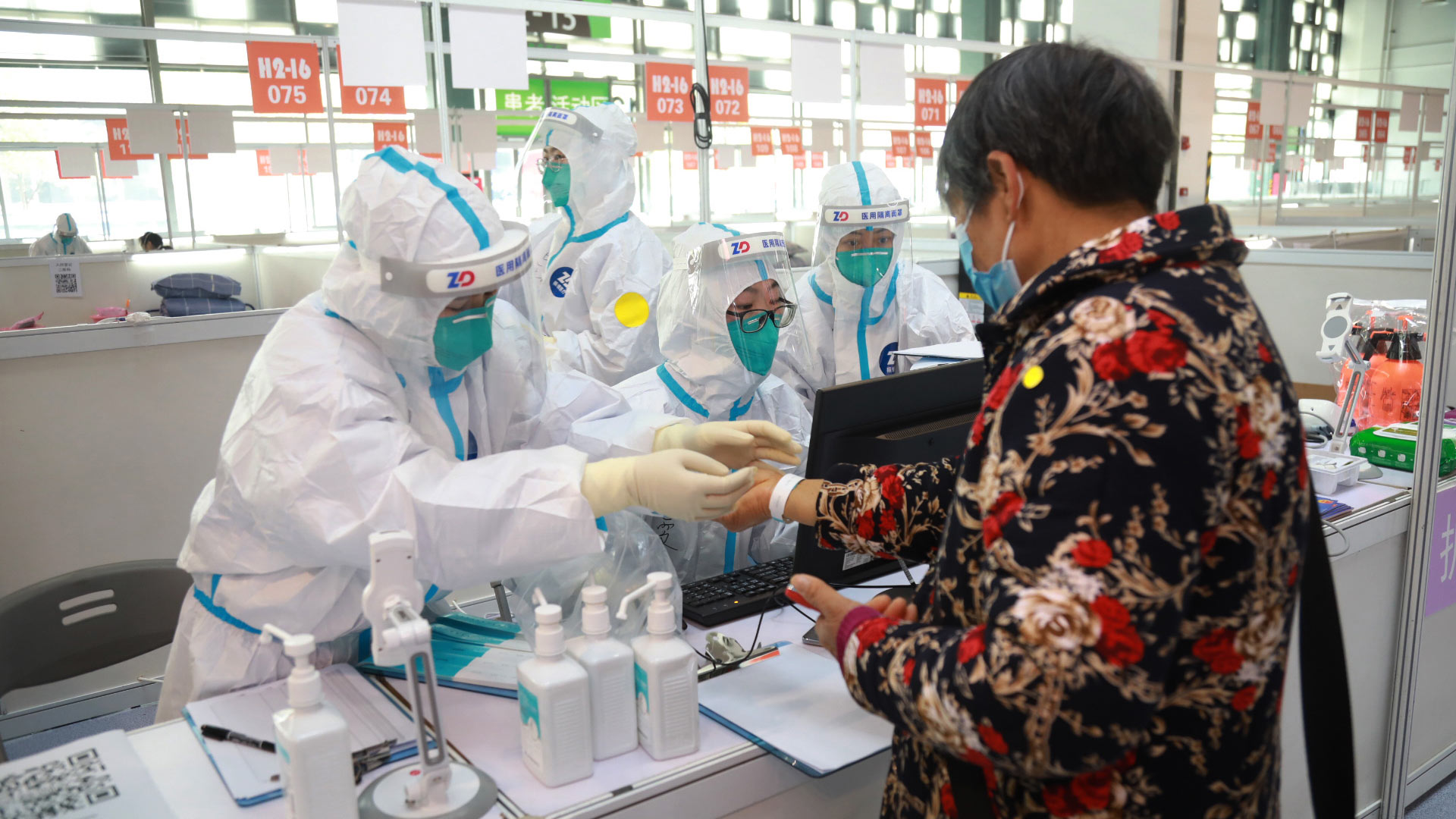 Mitarbeiter helfen einem Patienten bei der Registrierung in einer ausgewiesenen Quarantäneeinrichtung in der ostchinesischen Stadt Shanghai.  | picture alliance/dpa/XinHua
