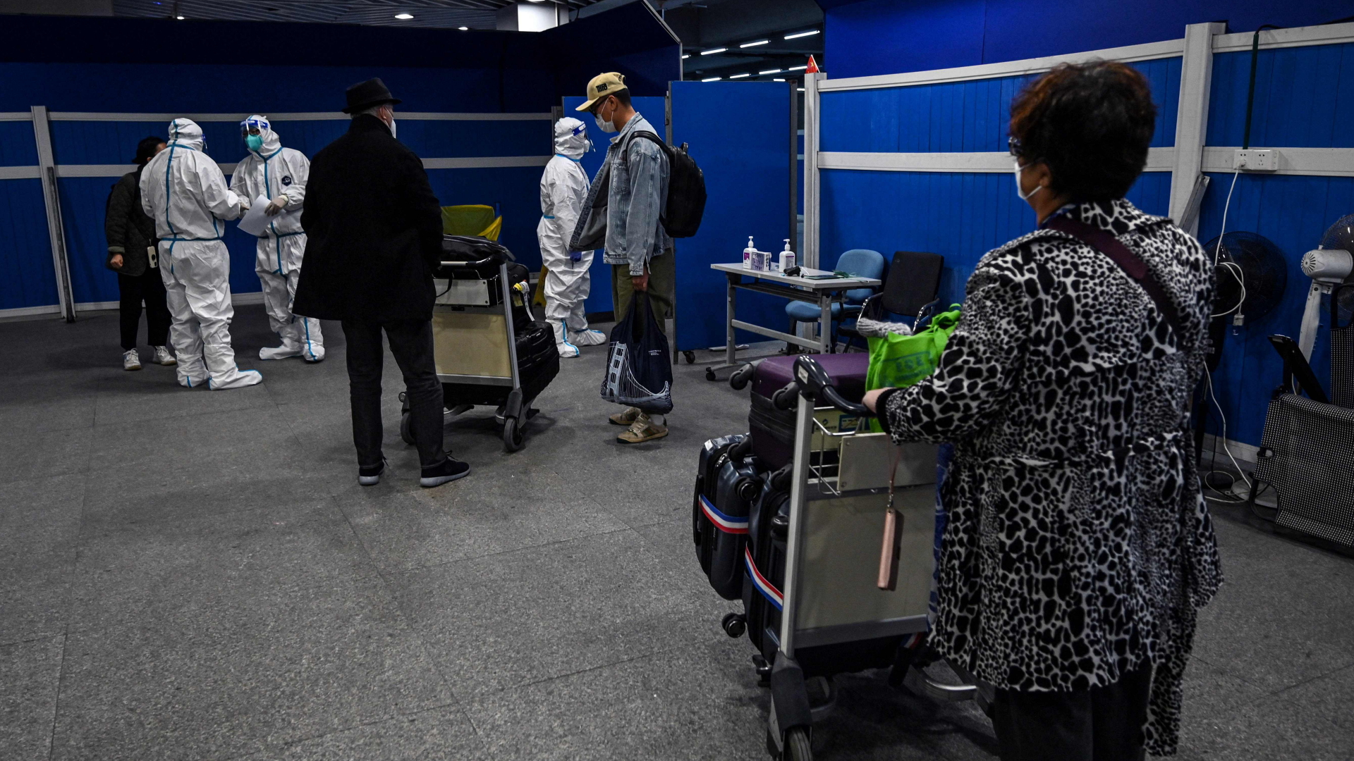 Ankommende an einem Flughafen in Shanghai warten darauf, in ihre Quarantäne-Hotels gebracht zu werden | AFP