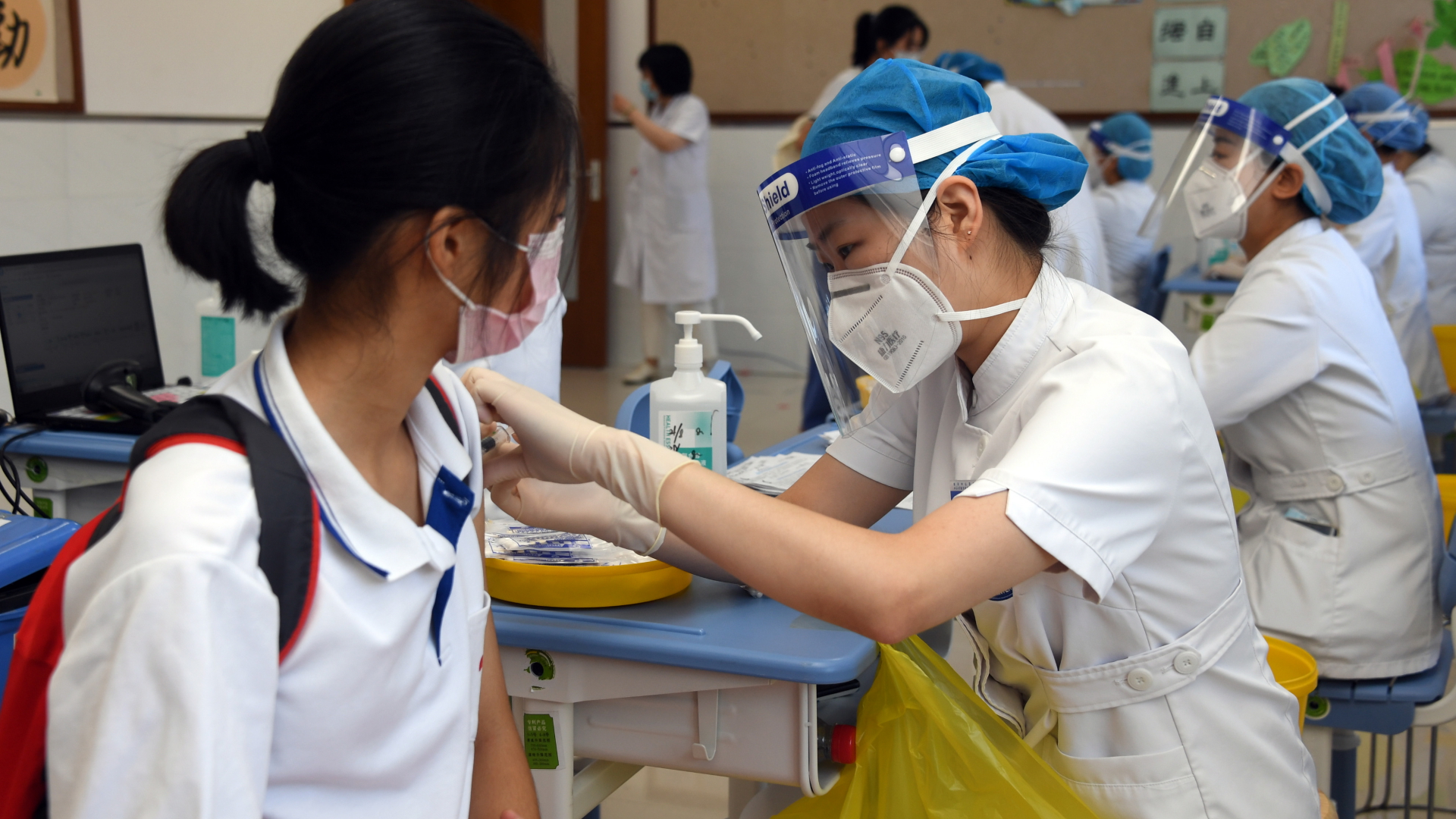 Eine junge Frau wird in Peking von einer medizinischen Mitarbeiterin gegen das Coronavirus geimpft. | dpa