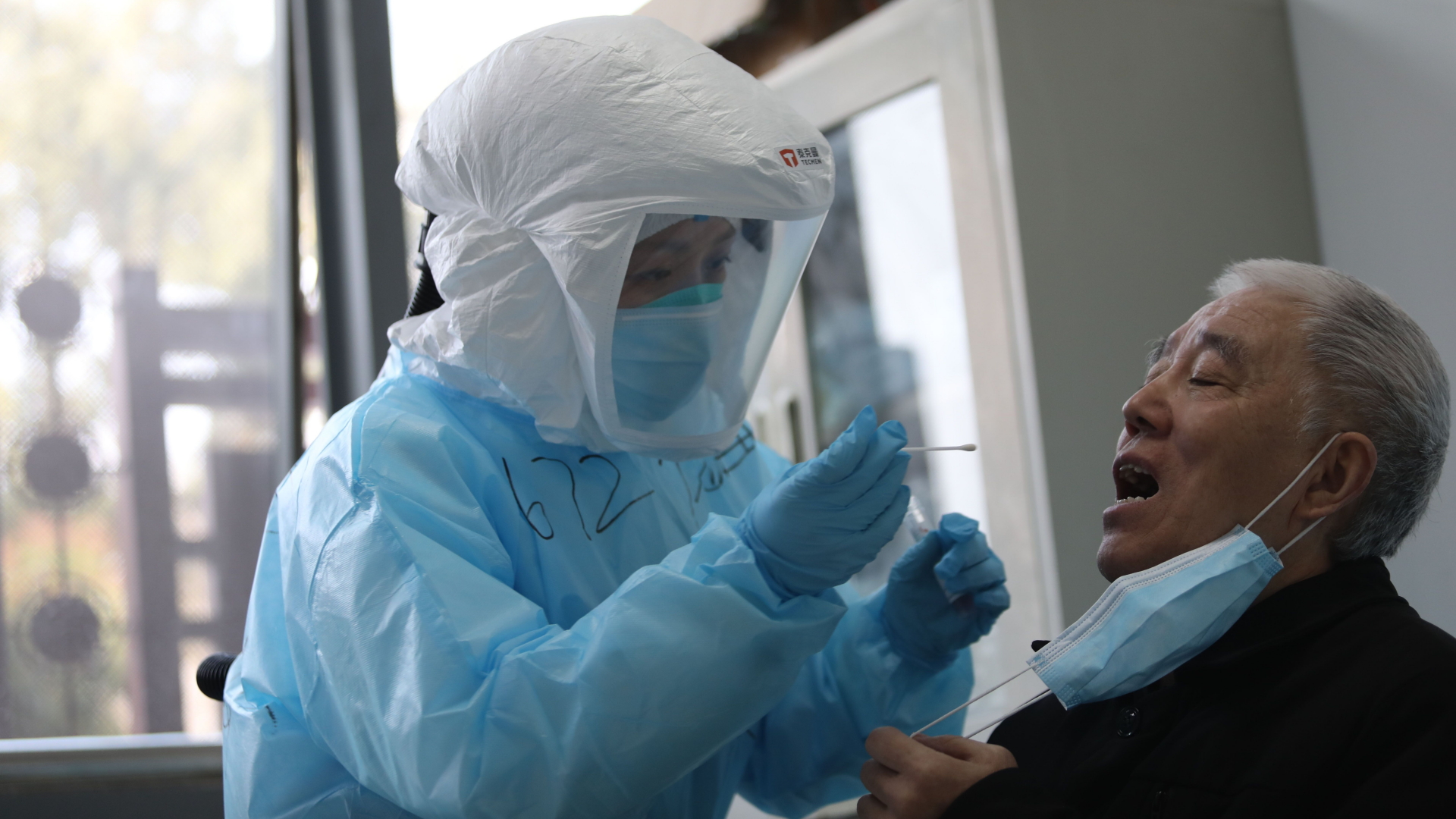 Die Mitarbeiterin einer Klinik in Wuhan untersucht einen Patienten. | AFP