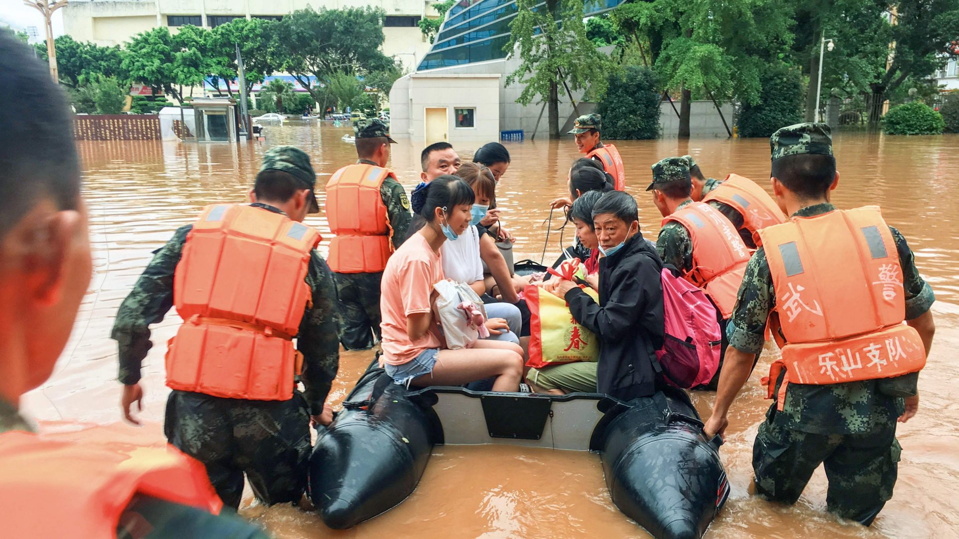 Soldaten retten mehrere Menschen mit einem Schlauchboot aus den Fluten. | AFP