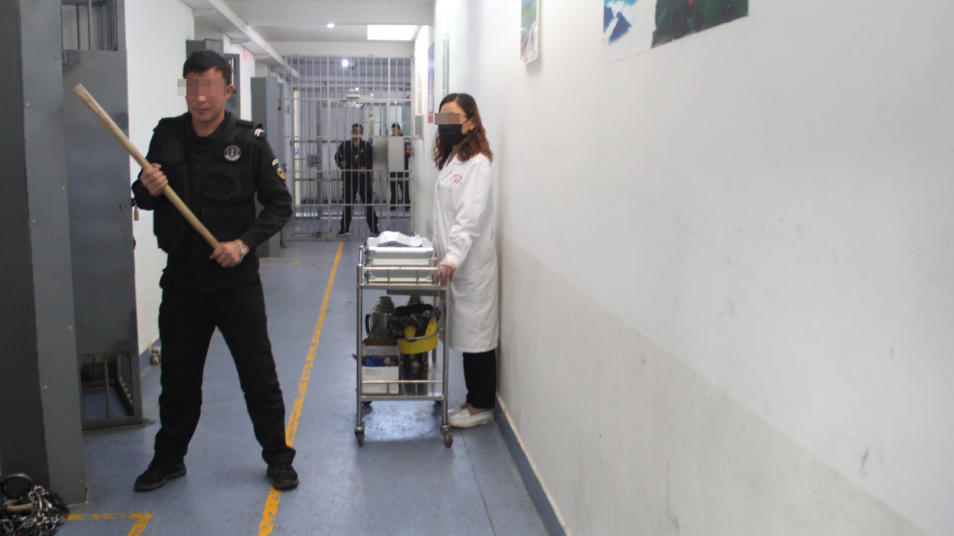 Çin'de ahşap sopalarla donanmış güvenlik güçleri bir gözaltı merkezinde duruyor.  |  Sincan Polis Dosyaları