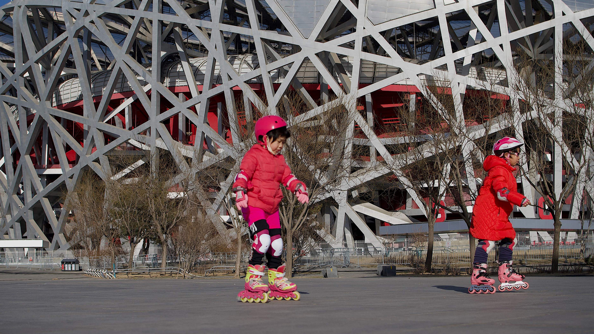 Kinder fahren mit ihren Inline-Skates vor dem Bird's Nest Stadion in Peking. | AFP