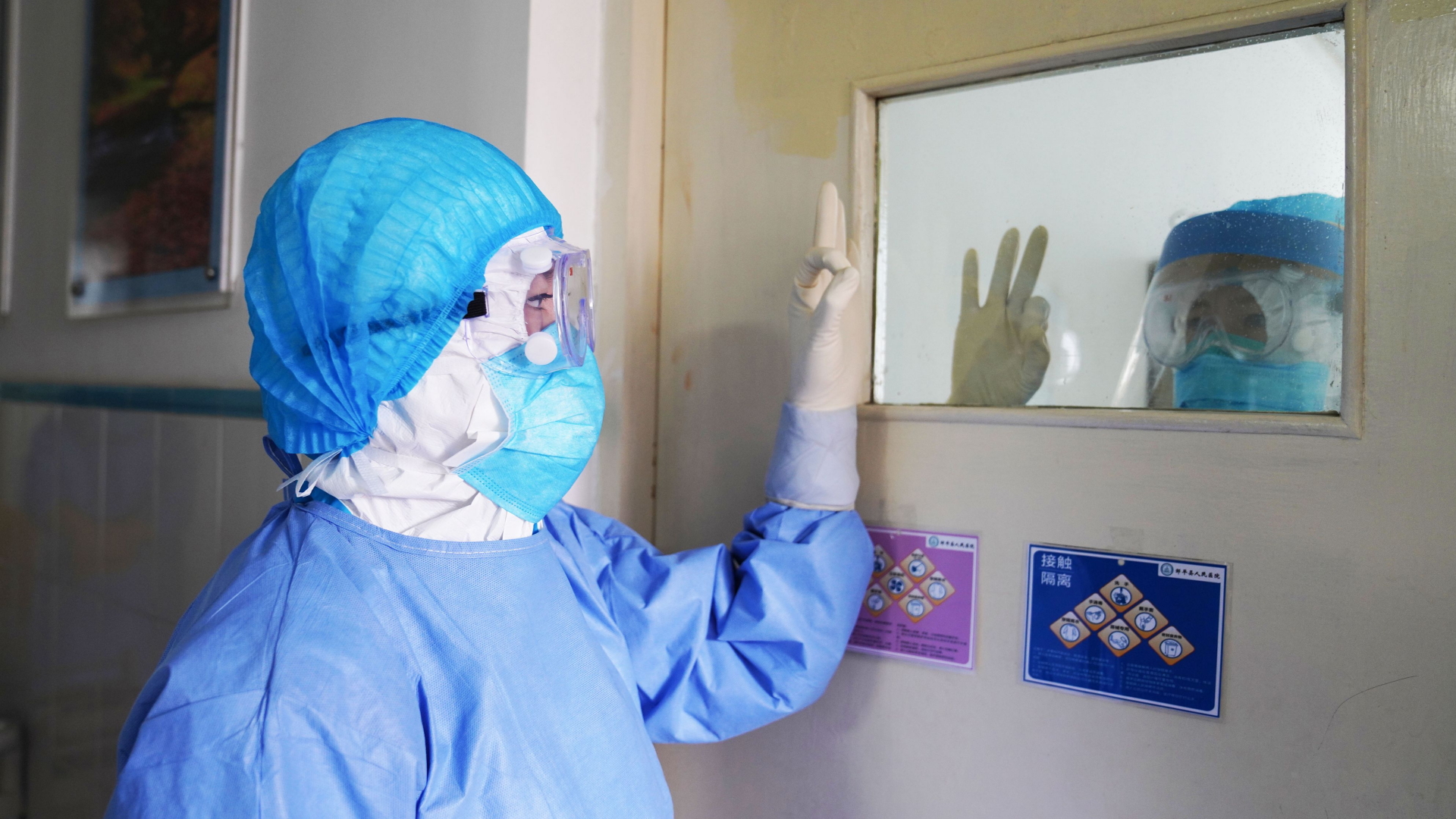 Mitarbeiter eines Krankenhauses in der chinesischen Stadt Zouping geben sich Handzeichen. (28. Januar) | AFP