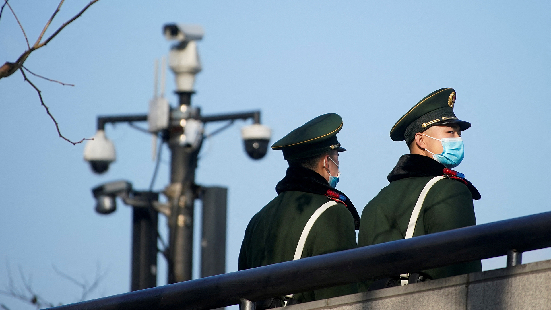 Paramilitärische Polizisten mit Schutzmasken stehen in Shanghai in der Nähe von Überwachungskameras. | REUTERS