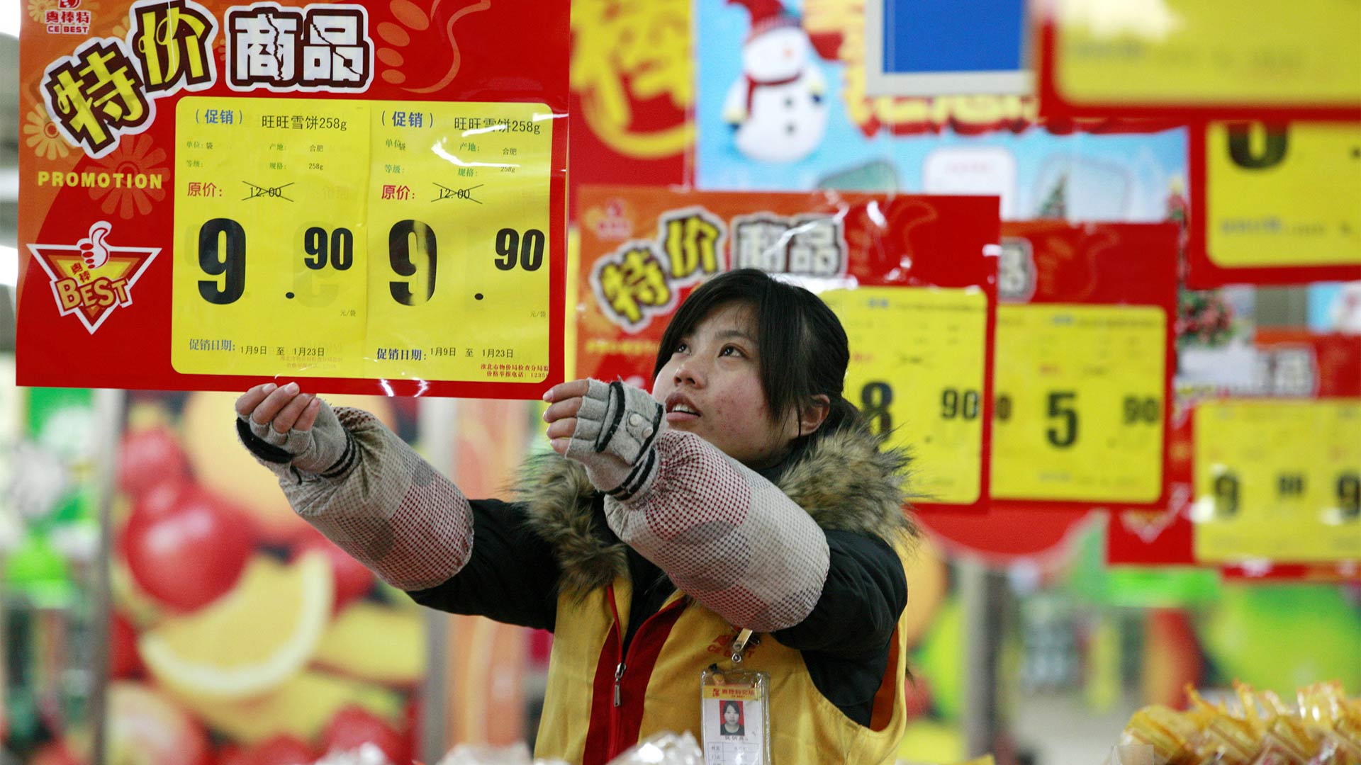 Mitarbeiterin eines Supermarktes in Huaibei, China, hängt neue Preisschilder auf.
