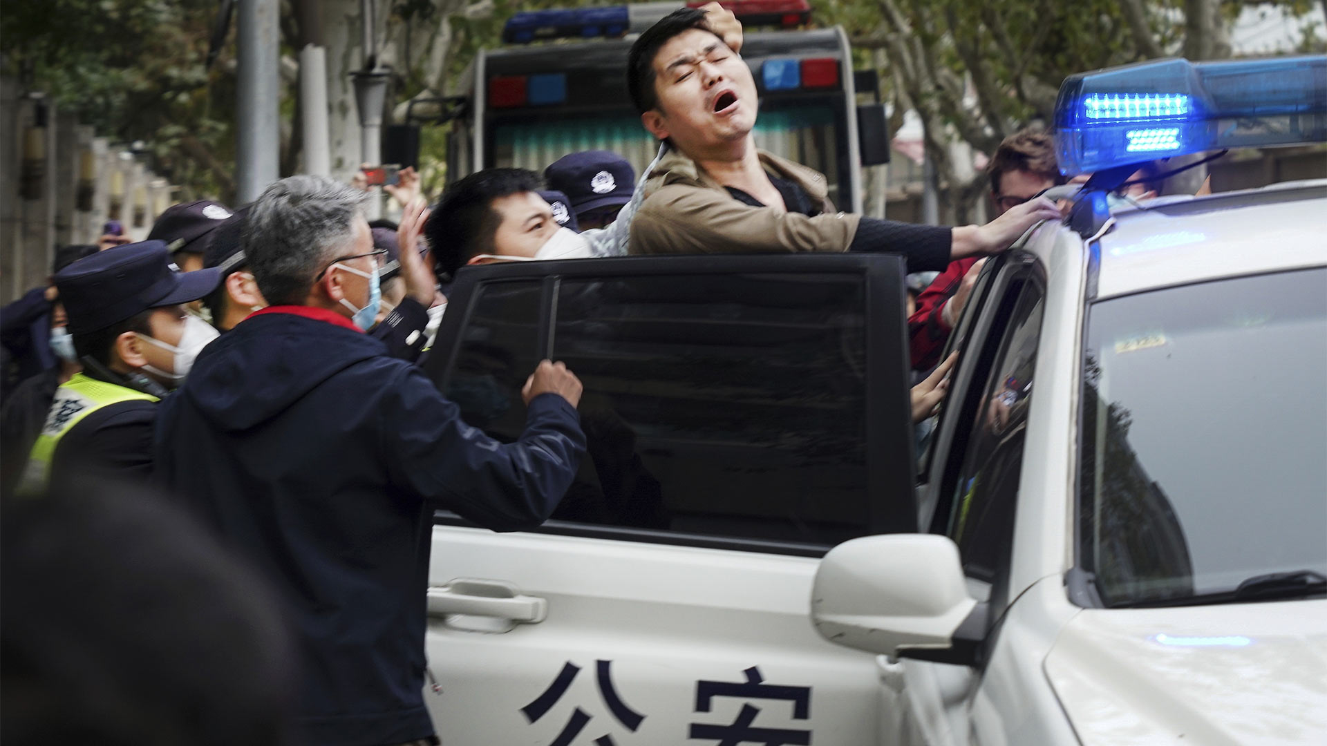 Ein Demonstrant wird bei Protesten gegen die rigorosen Null-Covid-Maßnahmen in China von Polizisten festgenommen (27.11.22). | picture alliance/dpa/Anonymous/A